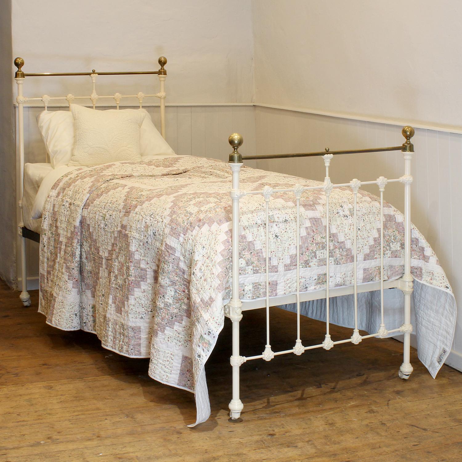 A traditional style Victorian antique bed painted in cream, with straight brass top rails, and decorative castings on the head and foot board. 
This bed takes a standard UK single 3ft wide x 6ft 3in long base and mattress, but will take a US twin