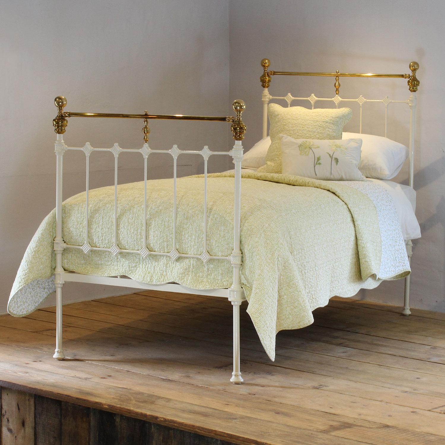 A traditional style Victorian antique bed painted in cream, with straight brass top rails, and decorative castings on the head and foot board. 
This bed takes a standard UK single 3ft wide x 6ft 3in long base and mattress, but will take a US twin
