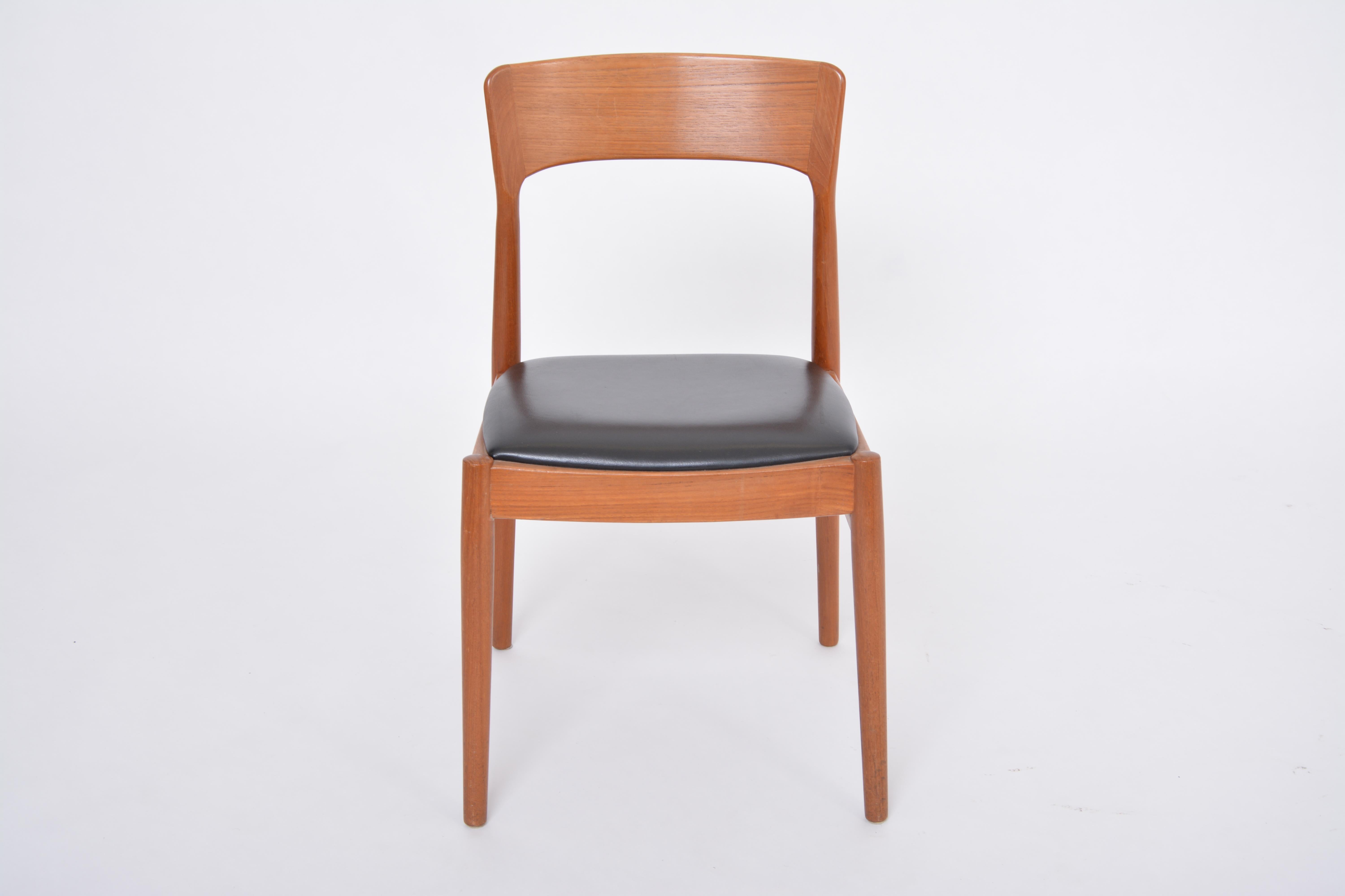 Single Danish Midcentury Modern Teak Chair
This dining or side chair was produced in Denmark, probably in the 1960s. It is made of a teak frame with a beautifully curved backrest and features a seat reupholstered in black faux leather. The generous