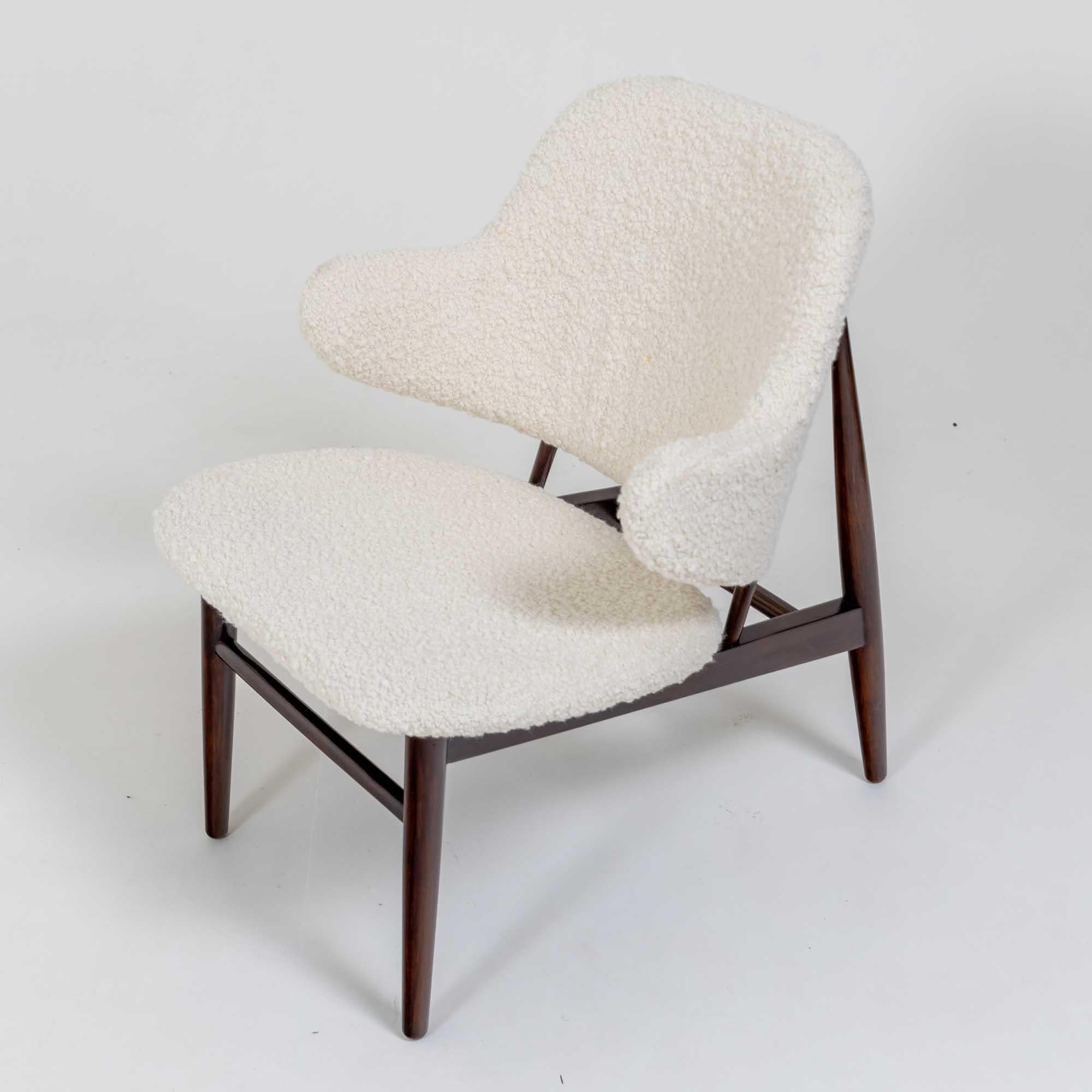 A decorative single Danish side chair on wooden base and legs. 
Upholstered in boucle fabric.