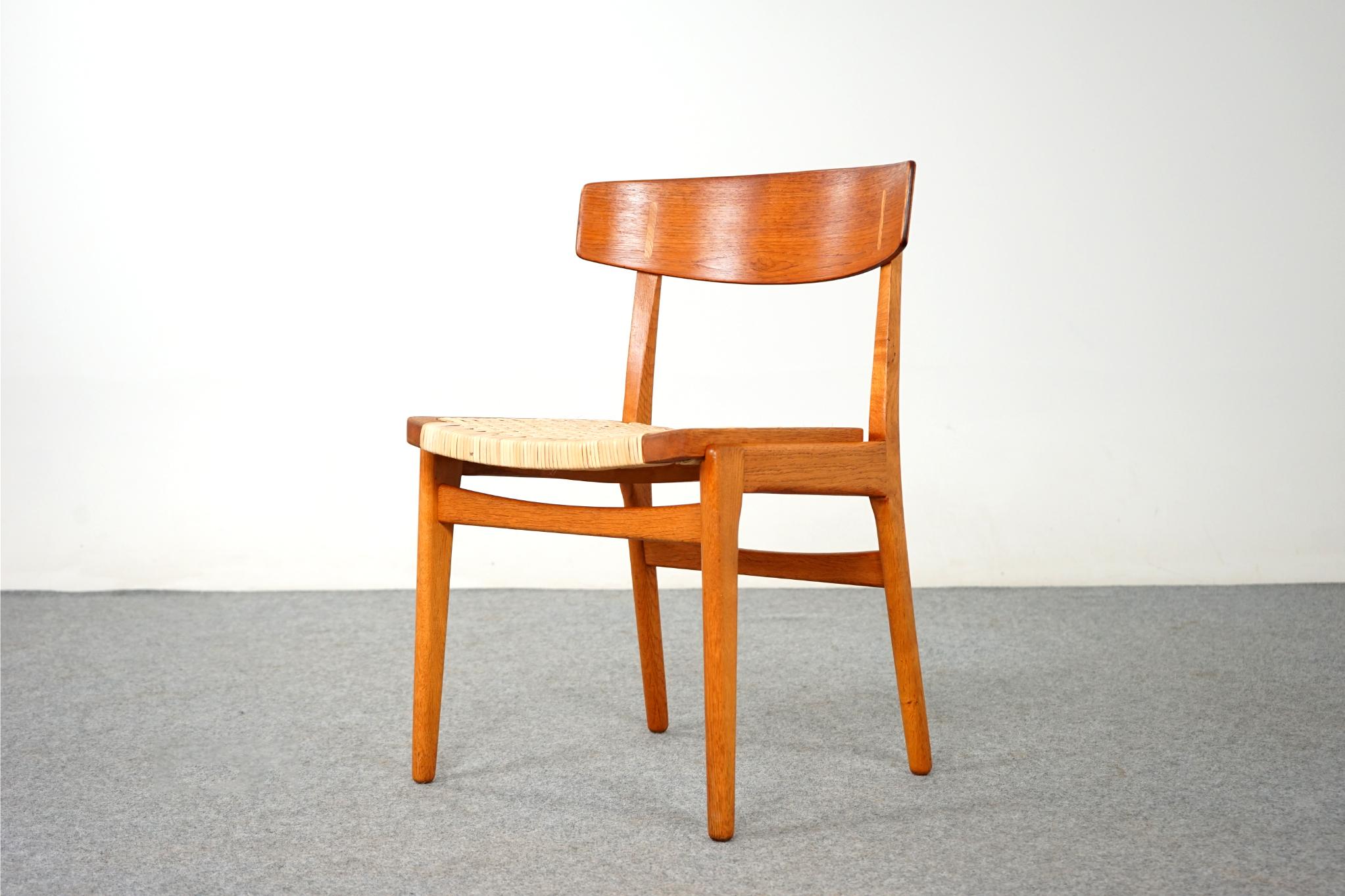Teak & oak dining chair, circa 1960's. Solid oak frame compliments the beautifully curved teak veneer seatback, with contrasting oak cover caps. Newly woven rattan seat is very comfortable! Excellent construction and quality.