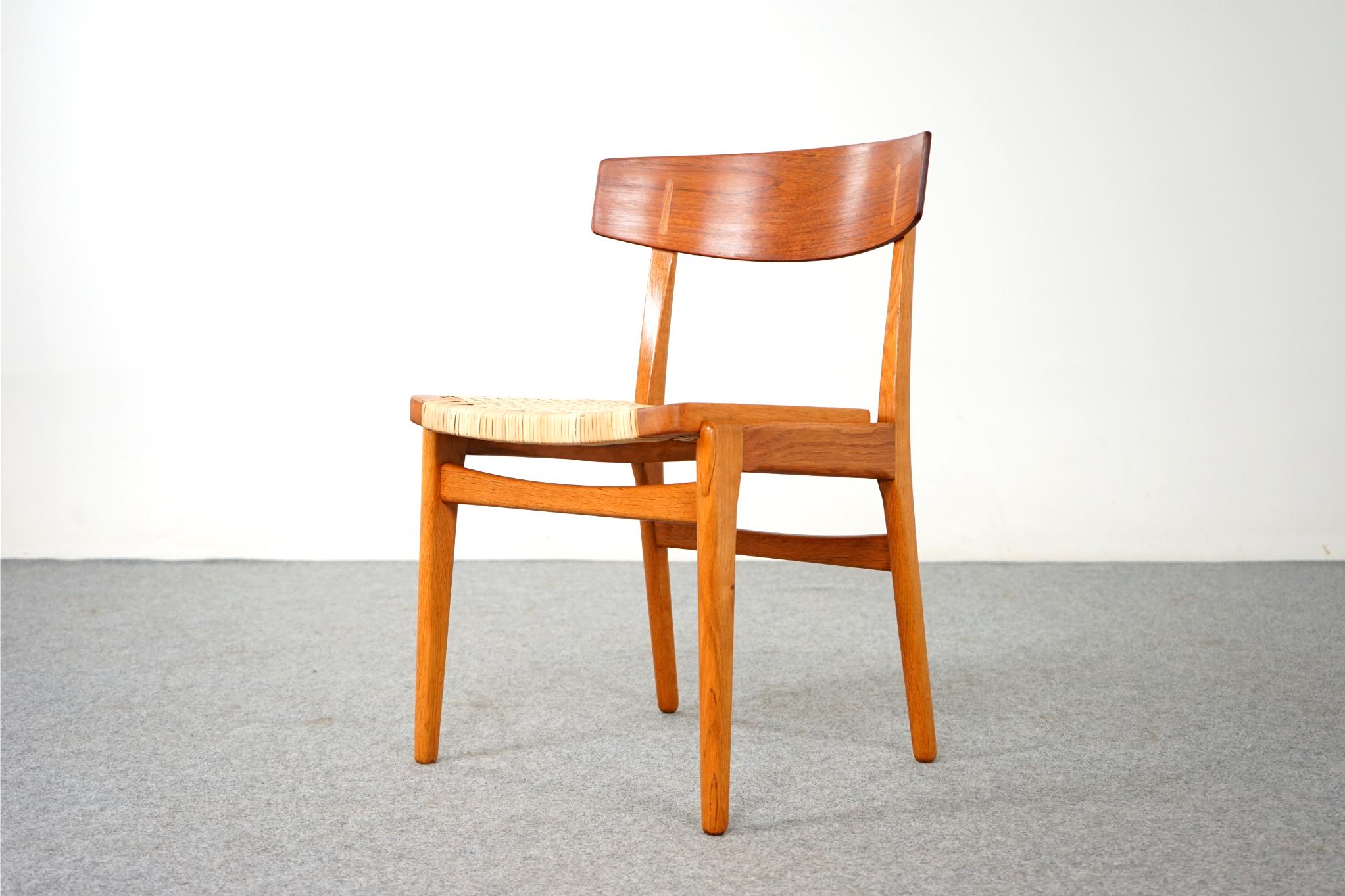 Teak & oak dining chair, circa 1960's. Solid oak frame compliments the beautifully curved teak veneer seatback, with contrasting oak cover caps. Newly woven rattan seat is very comfortable! Excellent construction and quality.

Please inquire for