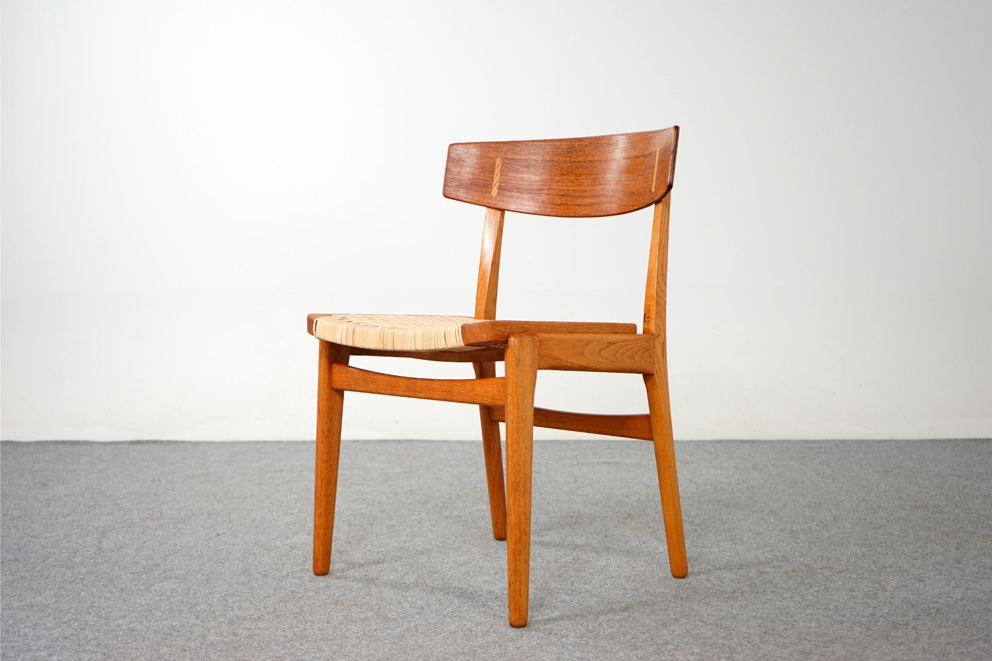 Teak & oak dining chair, circa 1960's. Solid oak frame compliments the beautifully curved teak veneer seatback, with contrasting oak cover caps. Newly woven rattan seat is very comfortable! Excellent construction and quality.

Please inquire for