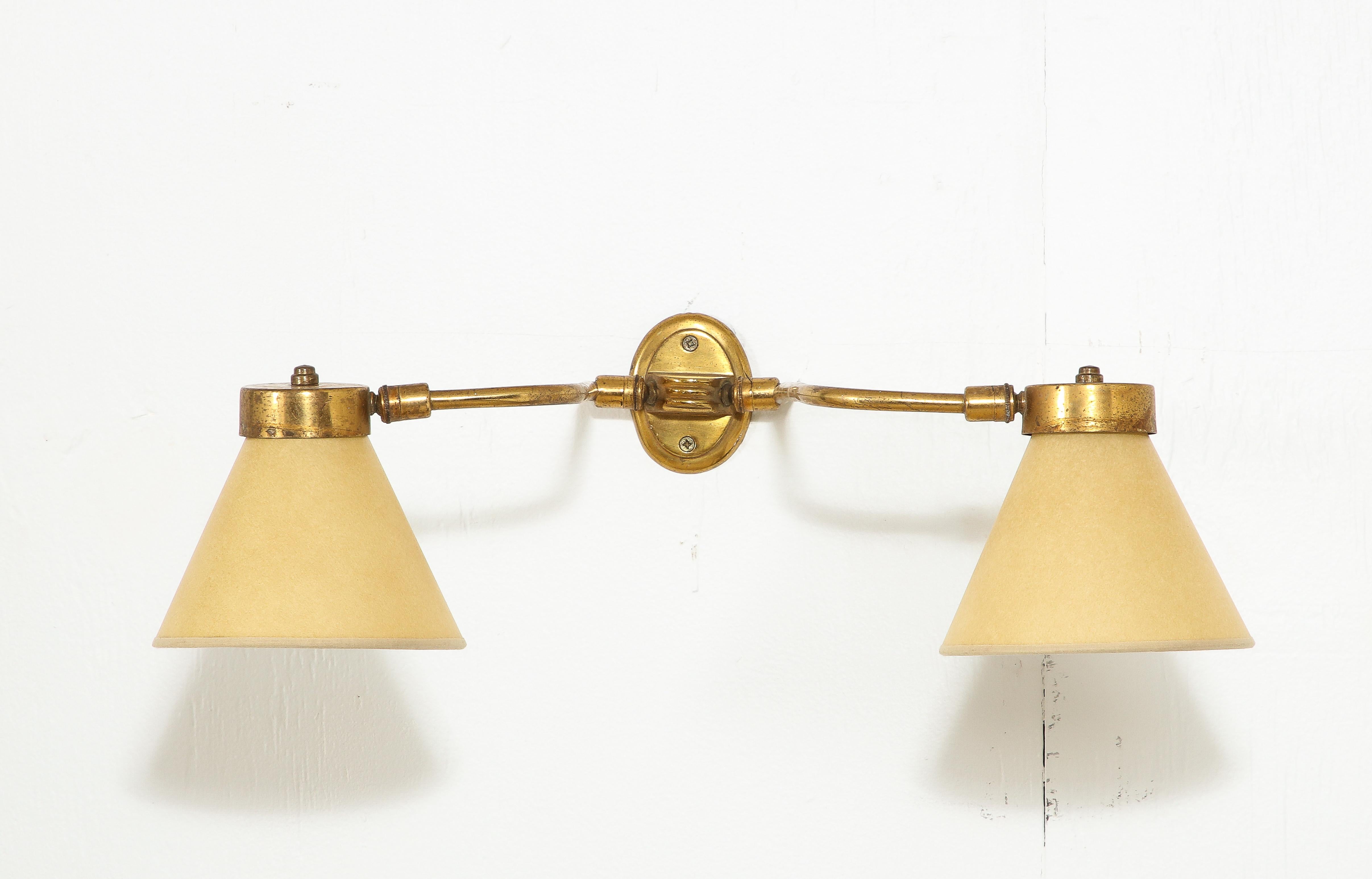 Single brass sconce with double-jointed arms and paper shades.
