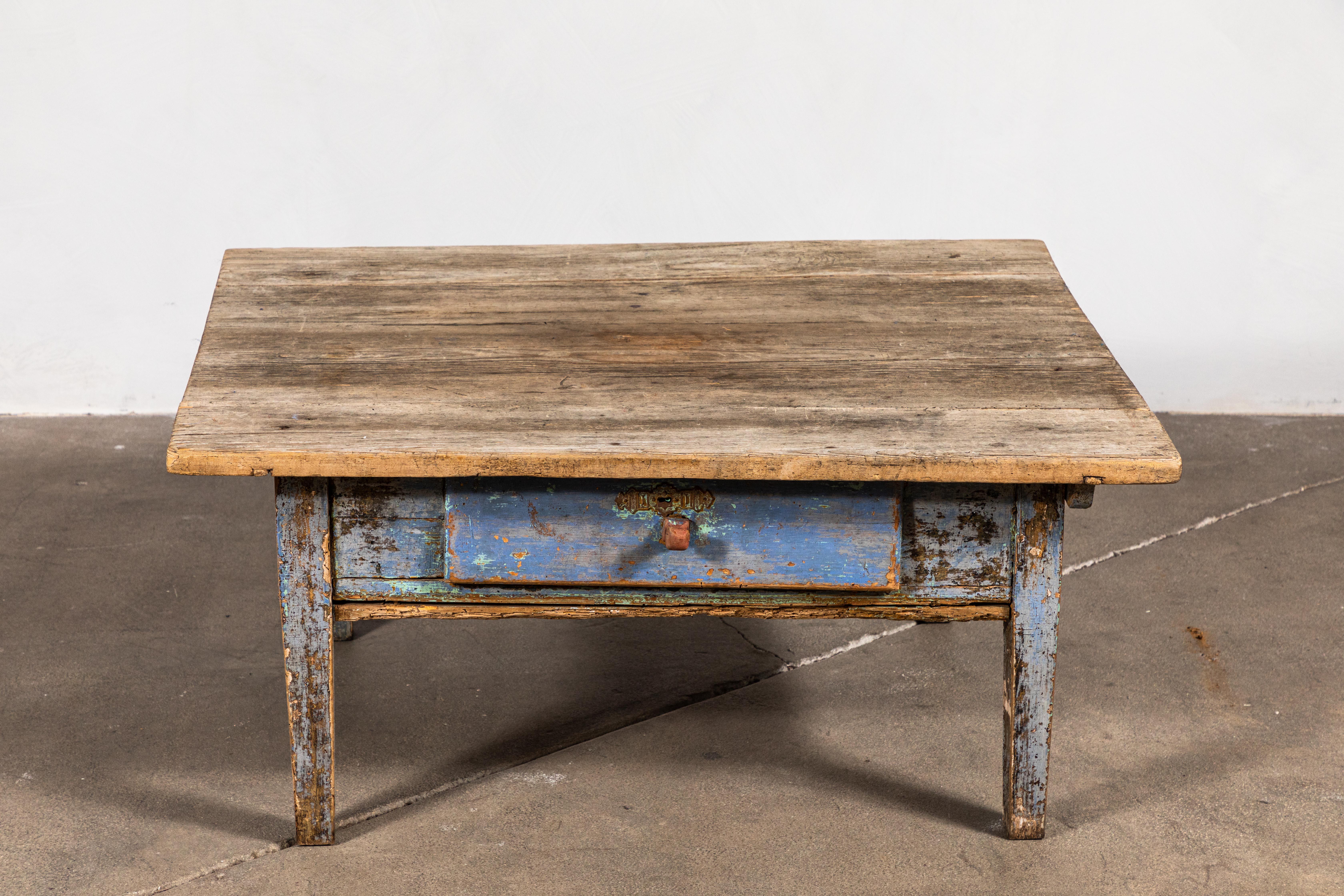 Rustic coffee table with single drawer with blue faded paint.