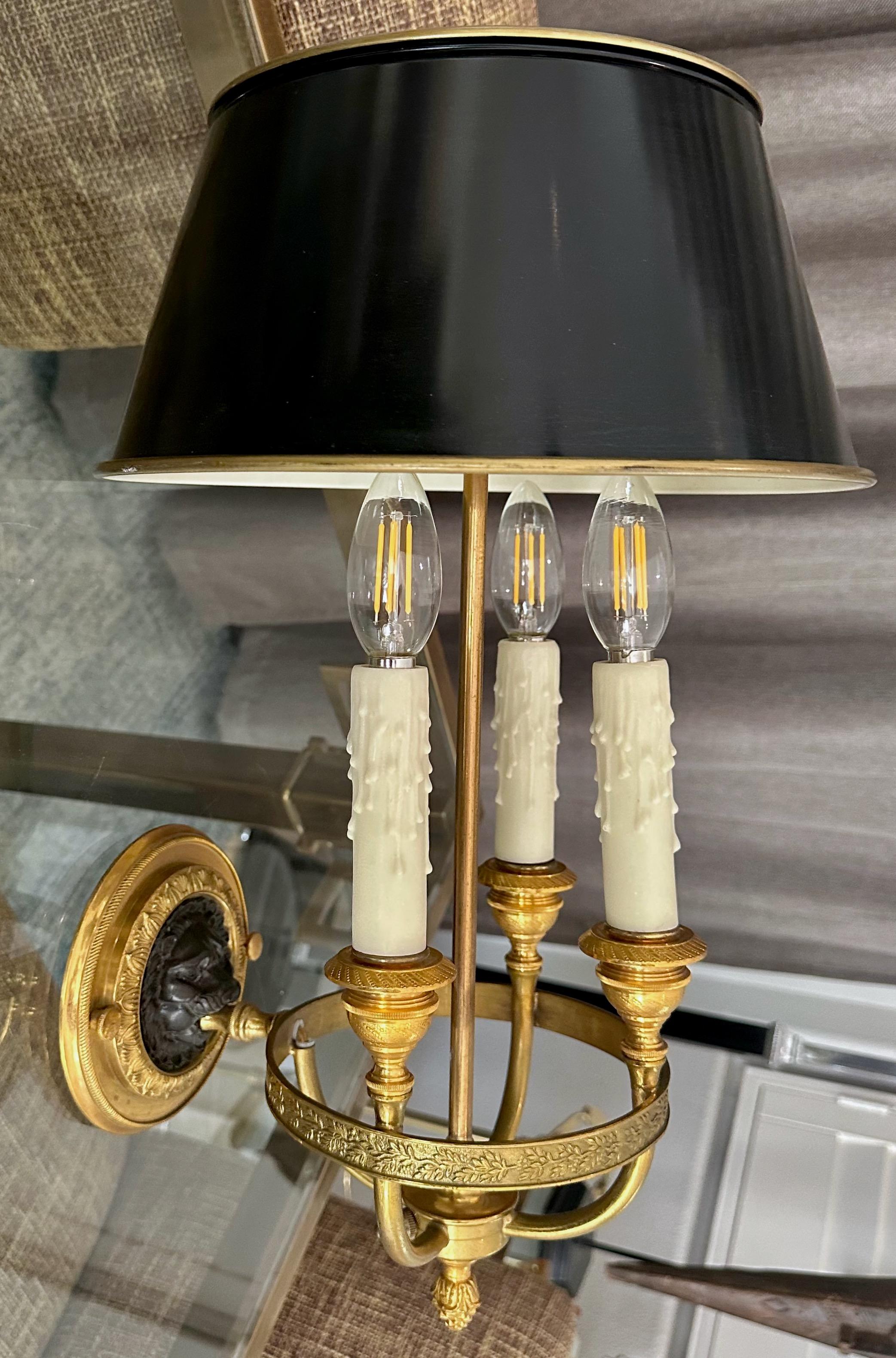 Large single French Empire style gilt bronze three light wall sconces with an open mouth lion motif. The sconce is expertly crafted with fine detailing through out. the sconce has an extending rod for a shade. the shade shown in photo is not