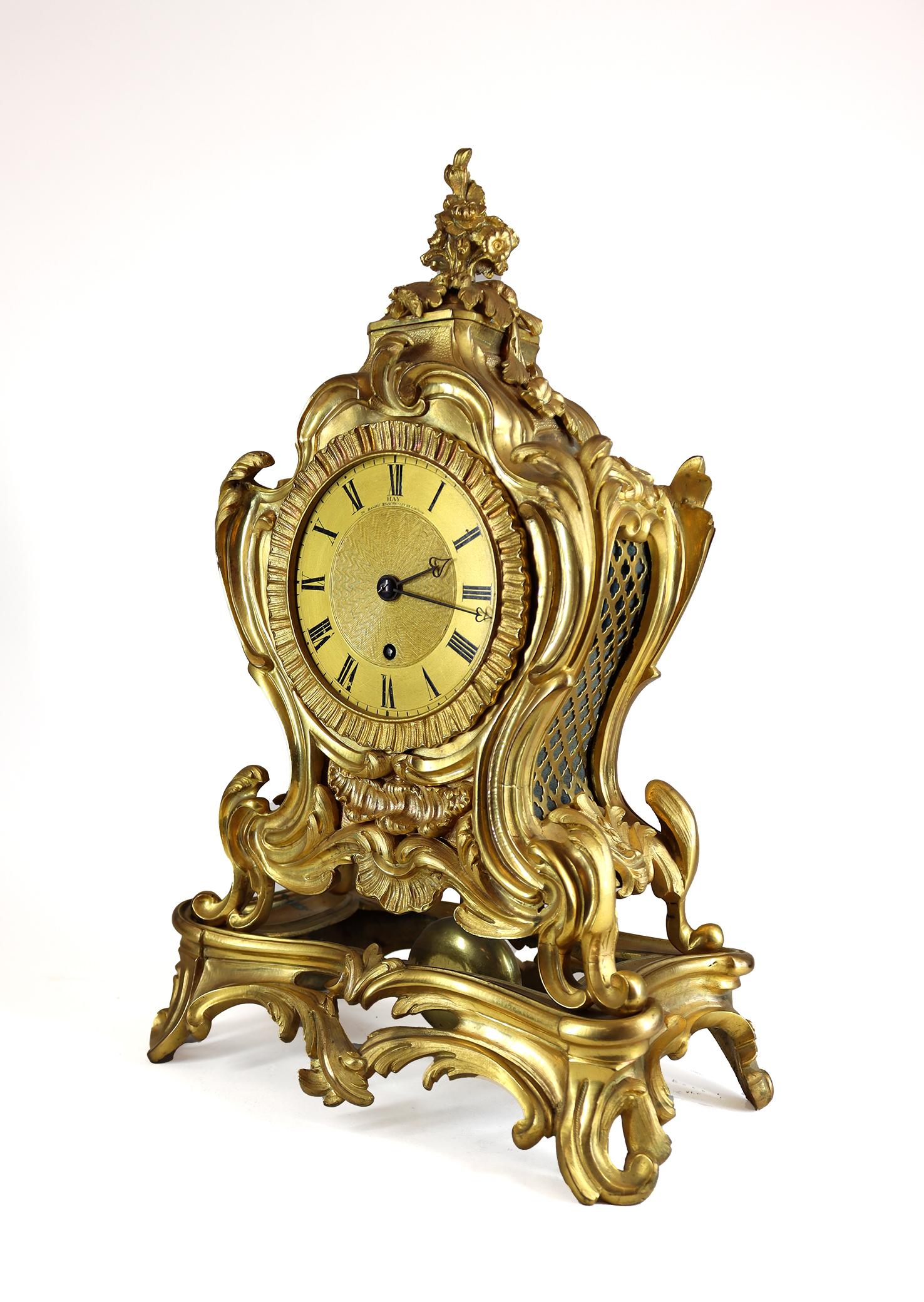 An unusual english single fusee mantel clock in a Louis XV style rocaille ormolu case in the french taste. The eight day fusee movement is of superb quality with a pendulum descending through the bottom of the case and visible though the pierced