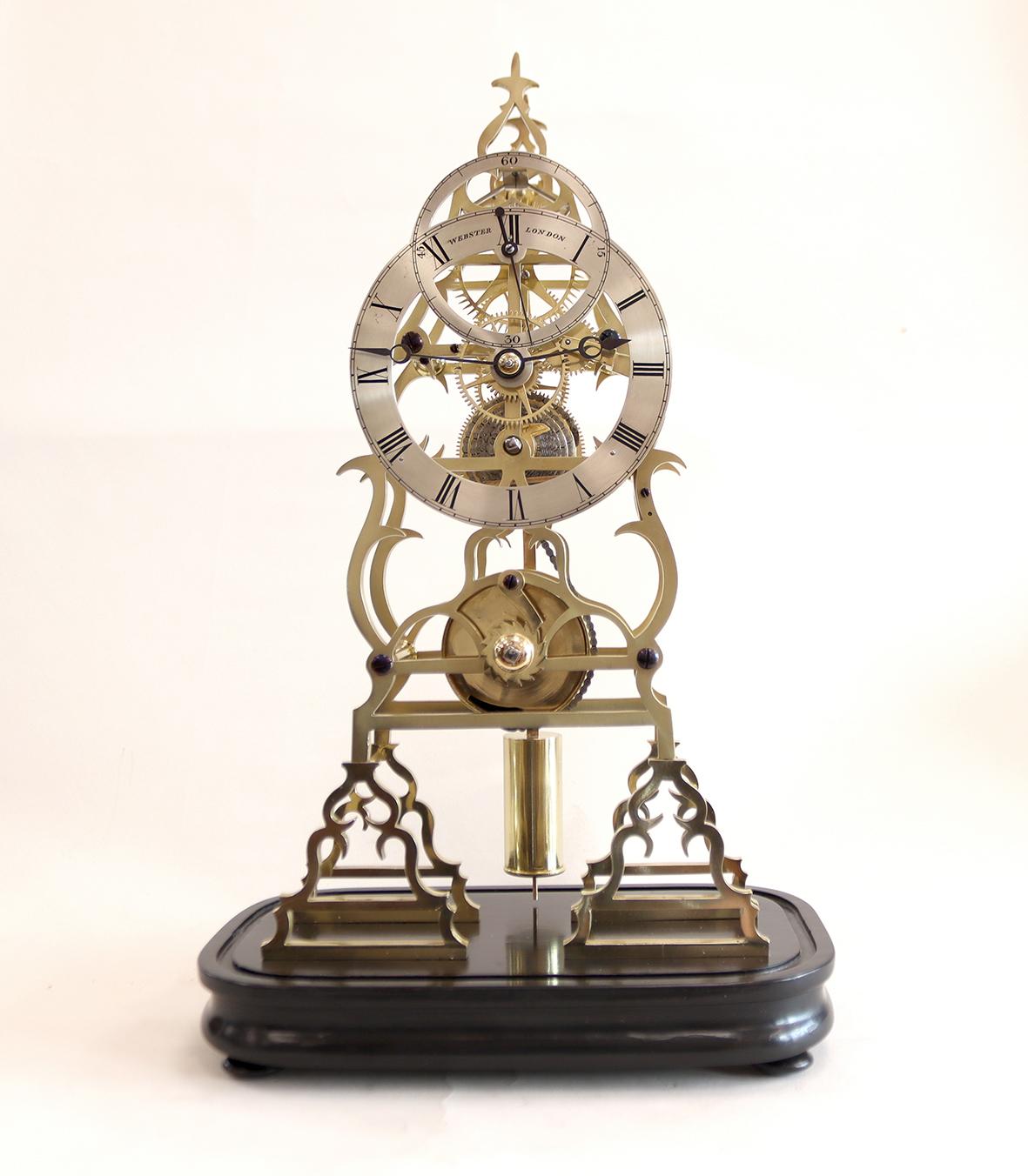 This highly decorative skeleton timepiece signed Webster, London has a single fusee eight day movement regulated by a brass cylinder pendulum. With a very finely made deadbeat escapement and sixty tooth escape wheel. The silvered roman dial is