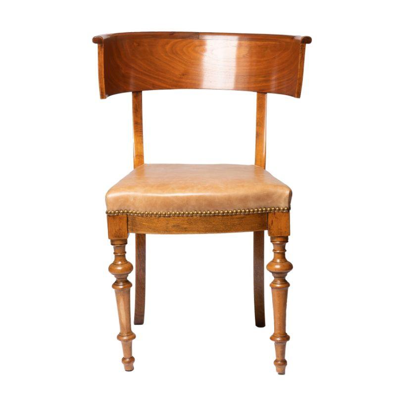 Single Klismos form side chair of European beech and figured mahogany veneer. The generously deep and wide curved back rail is supported by raked rear leg posts and turned front legs. The seat is upholstered in Italian oil tanned