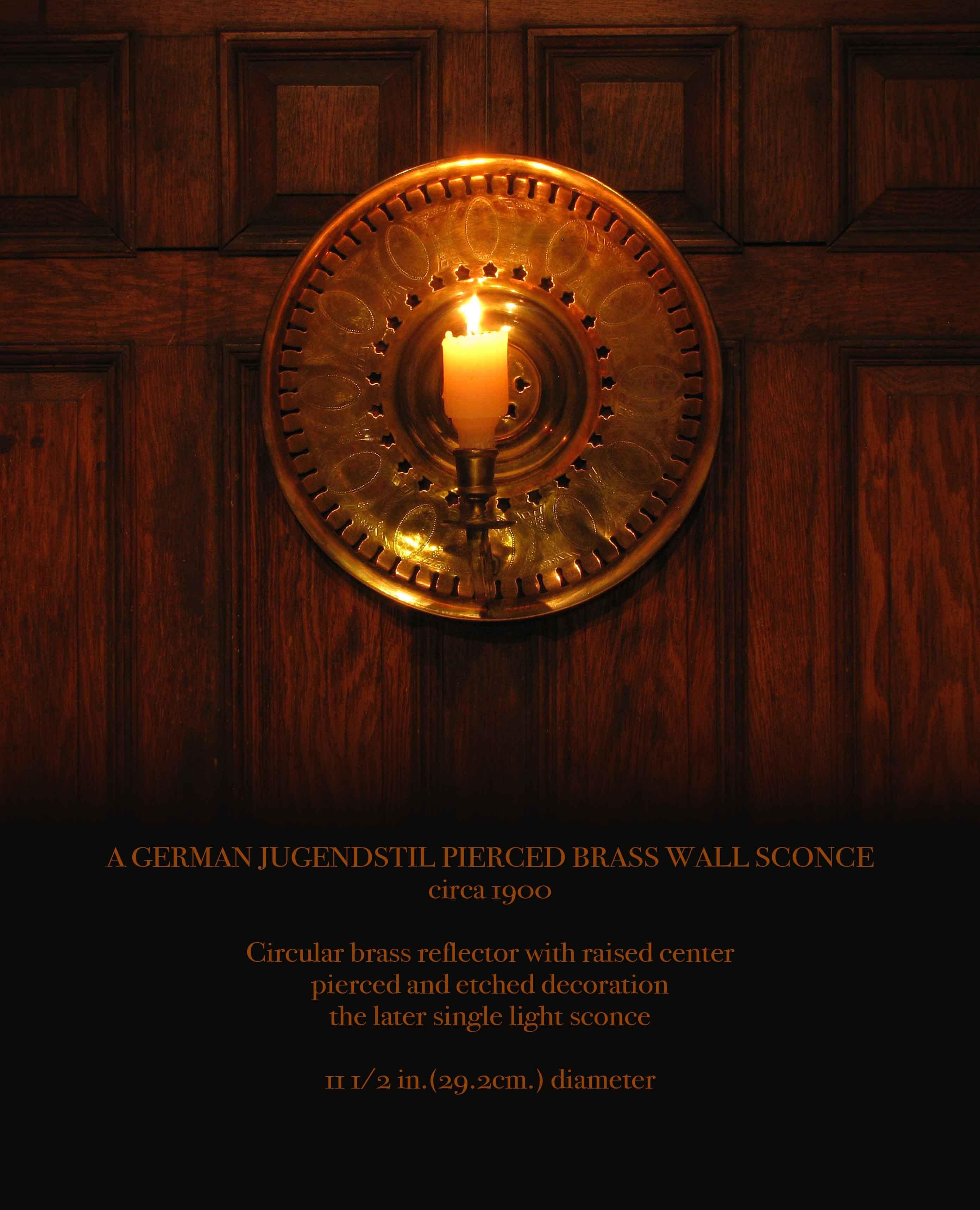 Ein deutscher Jugendstil-Wandleuchter aus durchbrochenem Messing.
um 1900.

Runder Messingreflektor mit erhöhter Mitte
durchbrochene und geätzte Dekoration
die spätere einflammige Wandleuchte.

Maß: 11 1/2