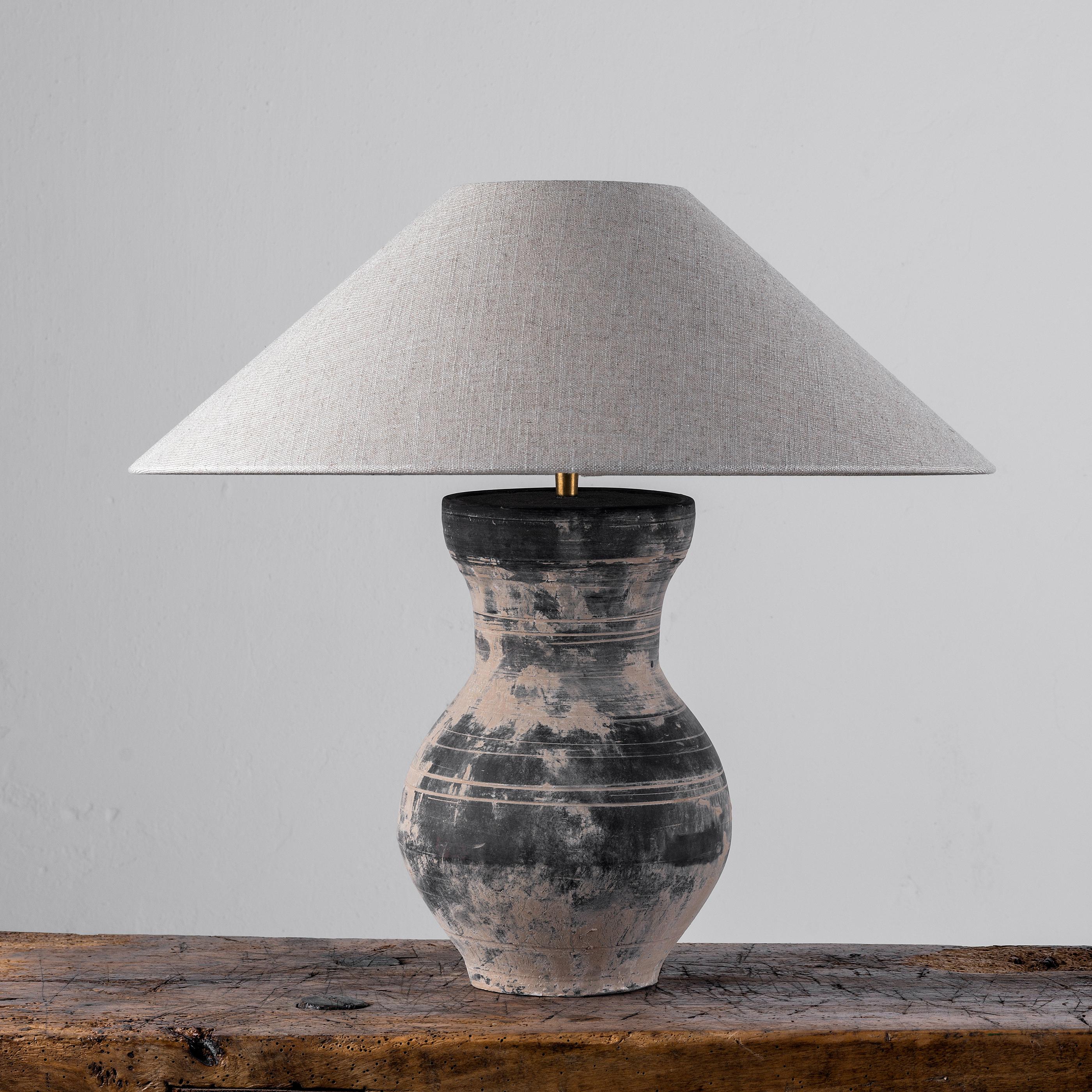 A beautiful unglazed Han dynasty style vase of a very elegant form.
Expectedly mounted as lamp - US WIRED. High quality mount with a brass adjustable pivot joint. 
The vase is from Zhejiang, china, mount and shade are made in Antwerp.
The Lamp is