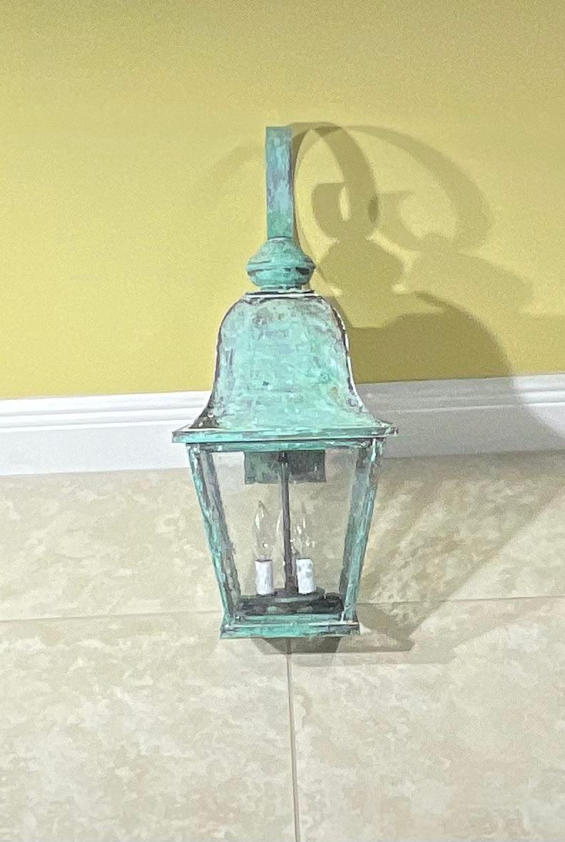 Quality wall lantern, handcrafted from solid brass with three 40/watt light ,seeded glass , up US code ,suitable for wet location. 
Beautiful greenish patina.