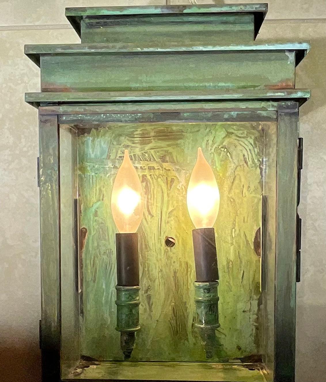 Hand crafted wall lantern made of solid brass .two 60/watt lights, clear glass, UL approved, suitable for wet location ready for use. Beautiful green oxidization patina.