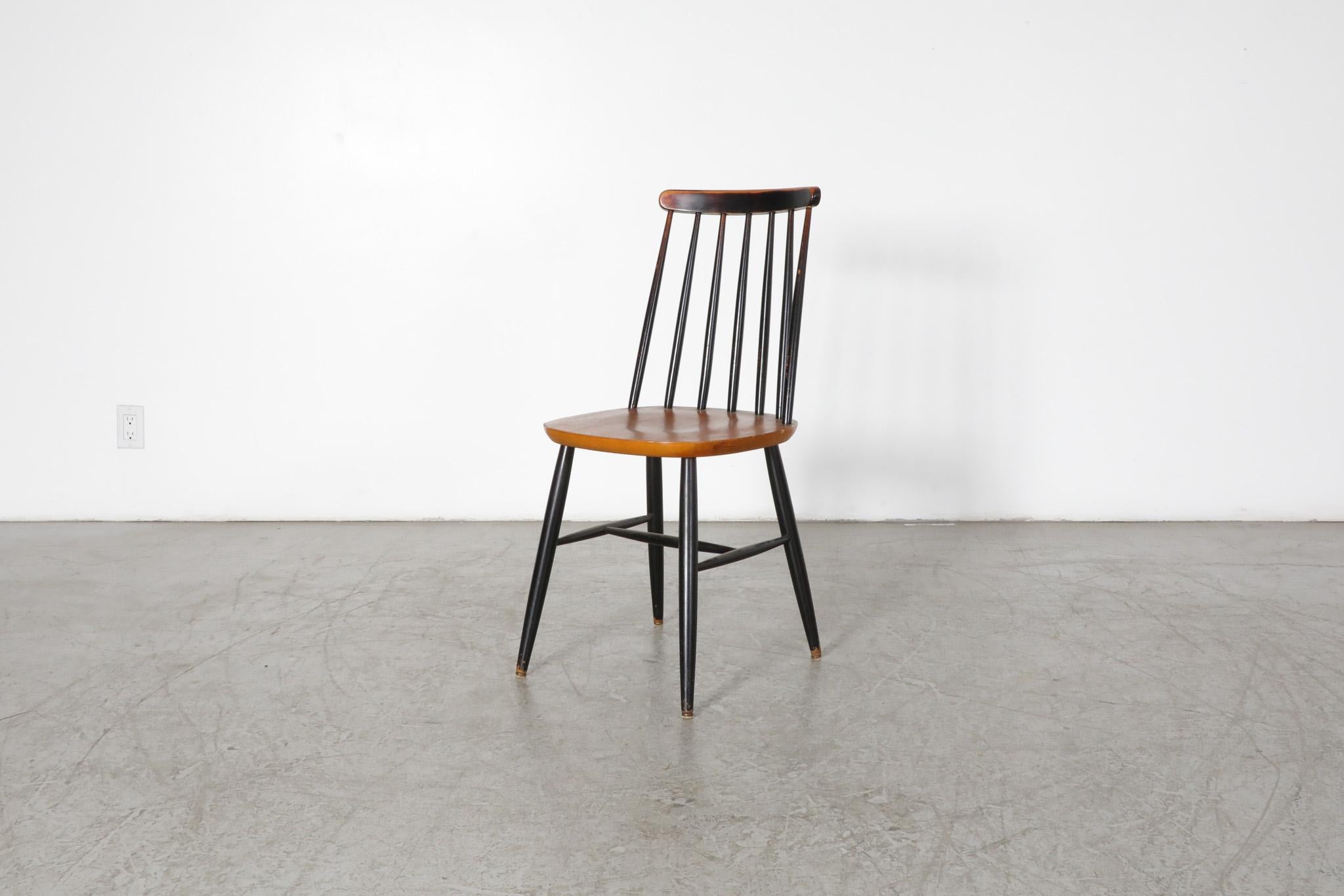 Wunderschöner, zweifarbiger, von Ilmari Tapiovaara inspirierter Stuhl mit Spindelrücken aus der Jahrhundertmitte. Einzelner Ess- oder Beistellstuhl mit schwarz gebeiztem Gestell und Sitz aus natürlichem Teakholz. Im Originalzustand mit