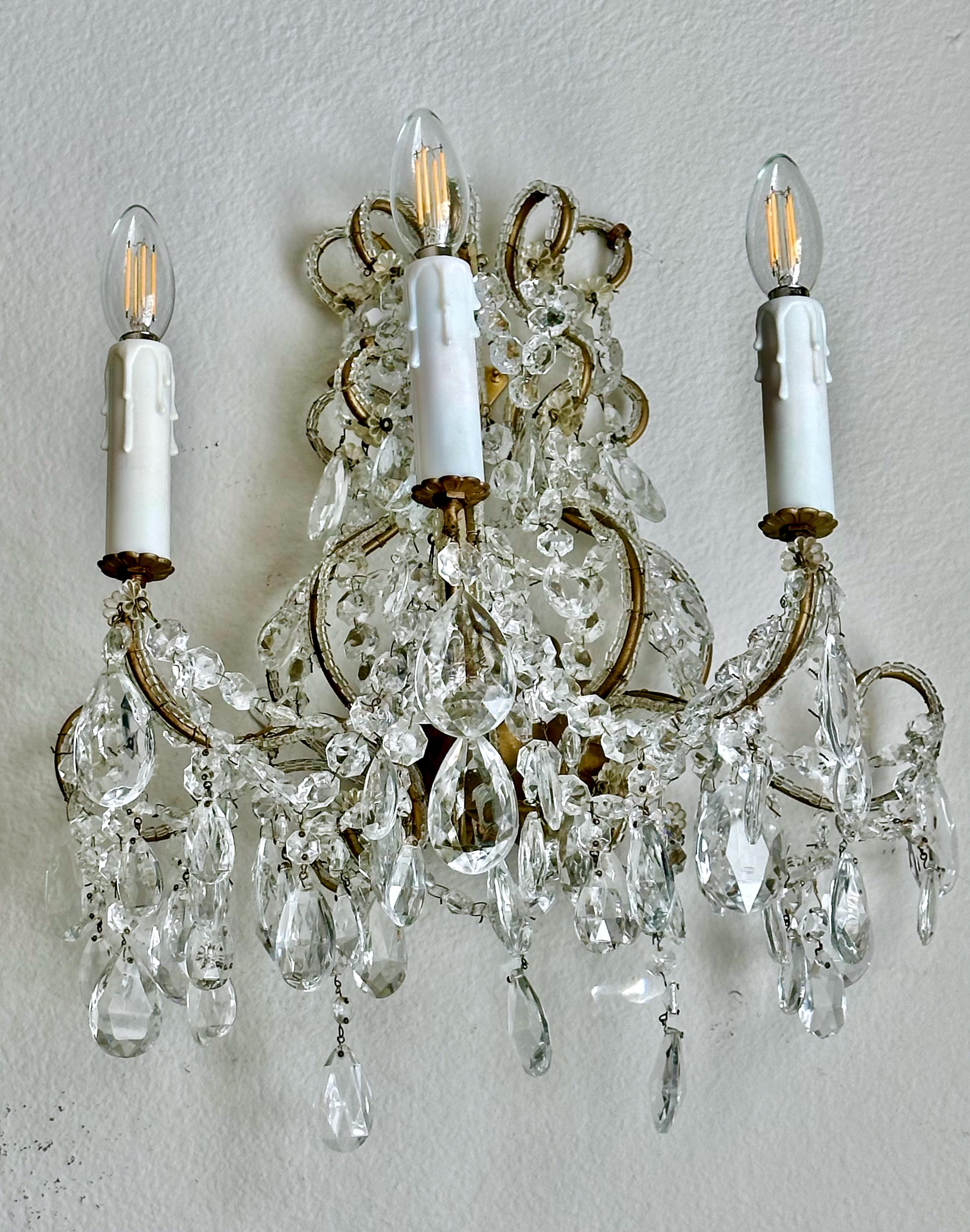 Single three-light Italian beaded gilt metal frame wall sconce with many multiple hanging crystal prisms.