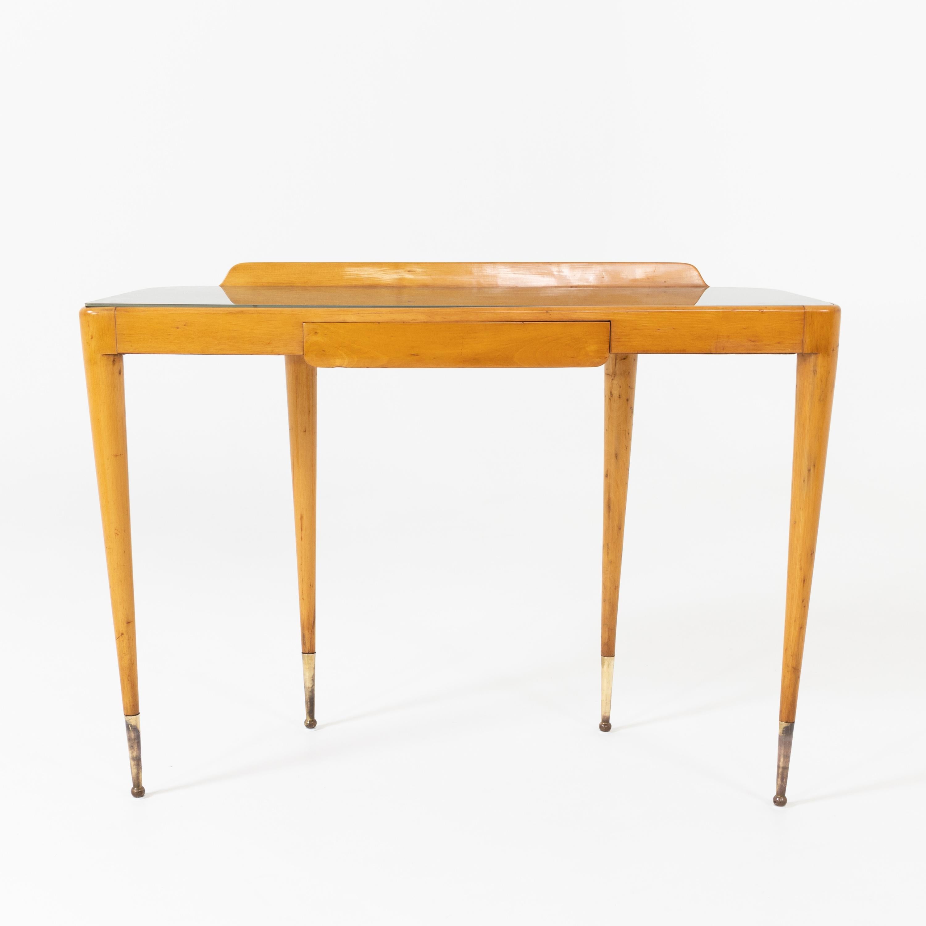 Italian modernist console table. 
Sycamore with original glass top, patinated brass sabots
and single drawer.