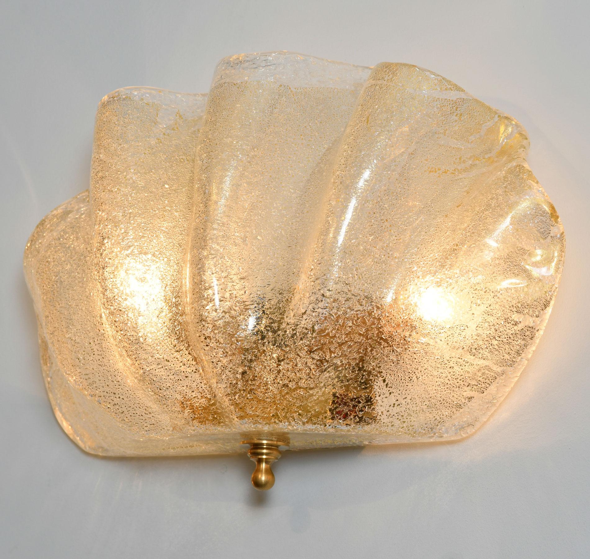 Contemporary textured subtle gold and clear Murano glass 'clam shell' wall light with gold fitting and decorative finial detailing. Exudes warm golden glow.
