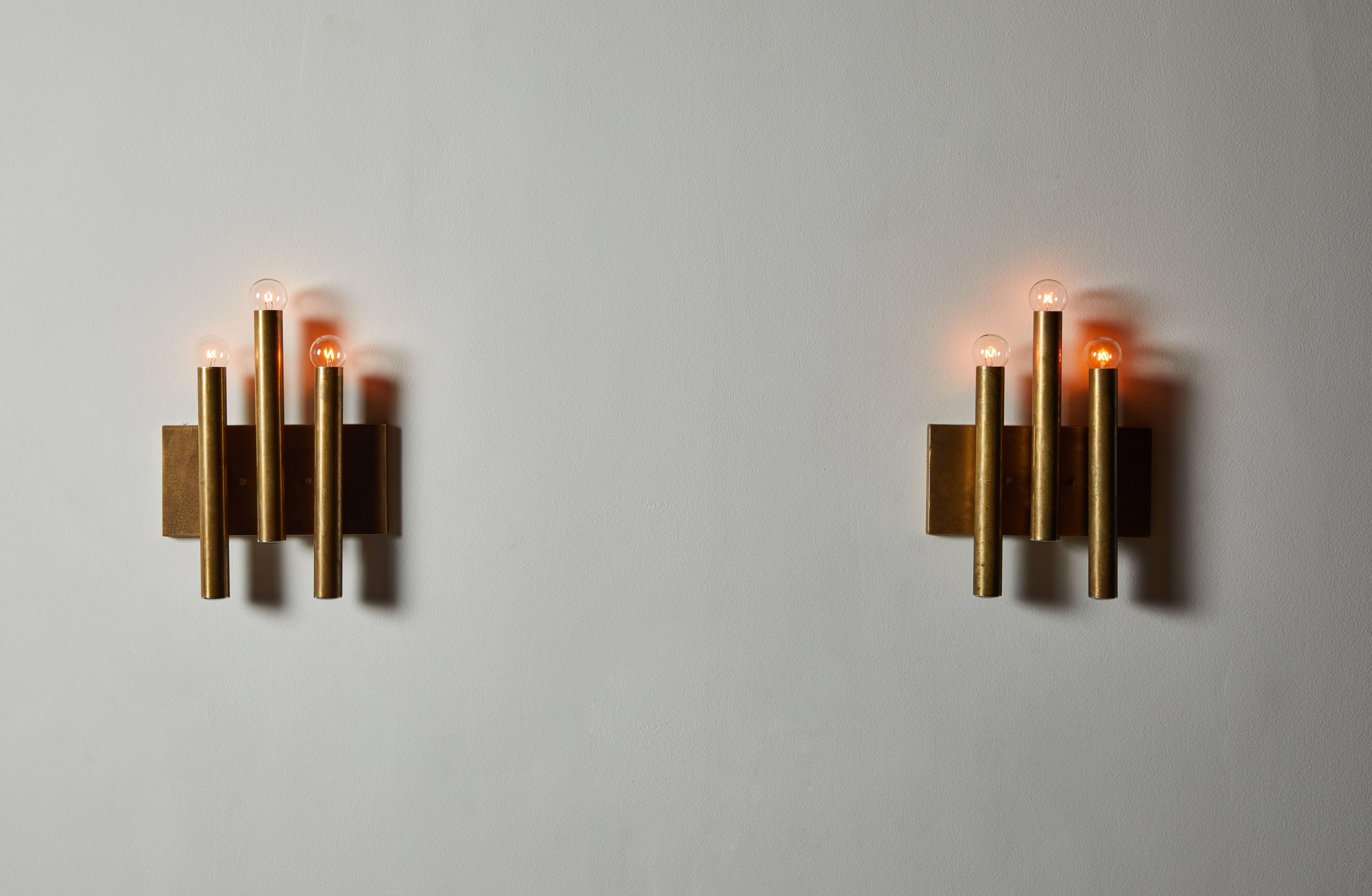 Single Italian sconce in the style of Gio Ponti for Candle. Designed and manufactured in Italy, circa 1960s. Patinated brass. Custom brass backplate. Rewired for US junction boxes. Light takes three E14 25w maximum European candelabra bulbs. 