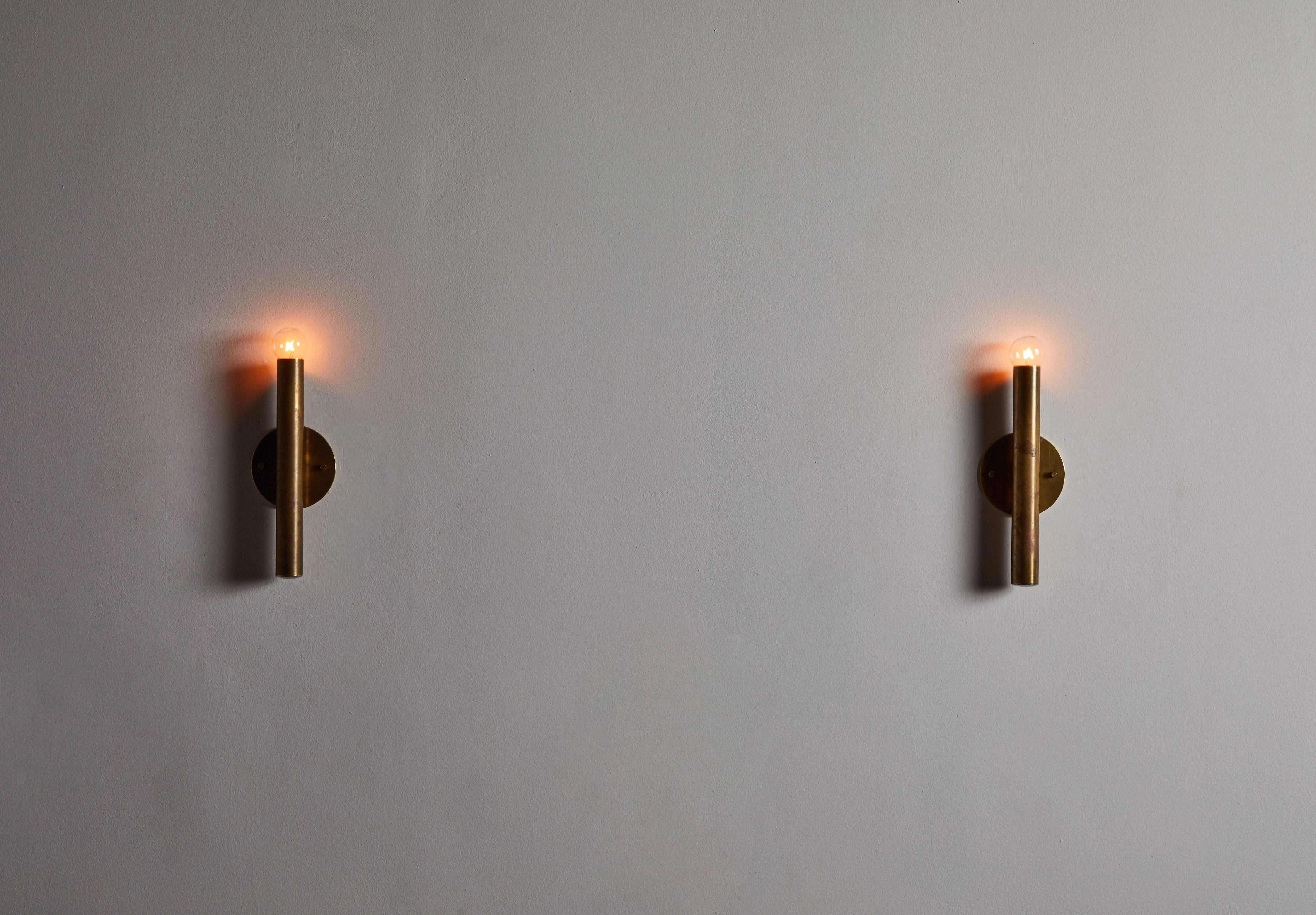 Single Italian sconce in the style of Gio Ponti for candle. Designed and manufactured in Italy, circa 1960s. Patinated brass. Custom brass backplate. Light takes one E14 75w maximum European candelabra bulb. 