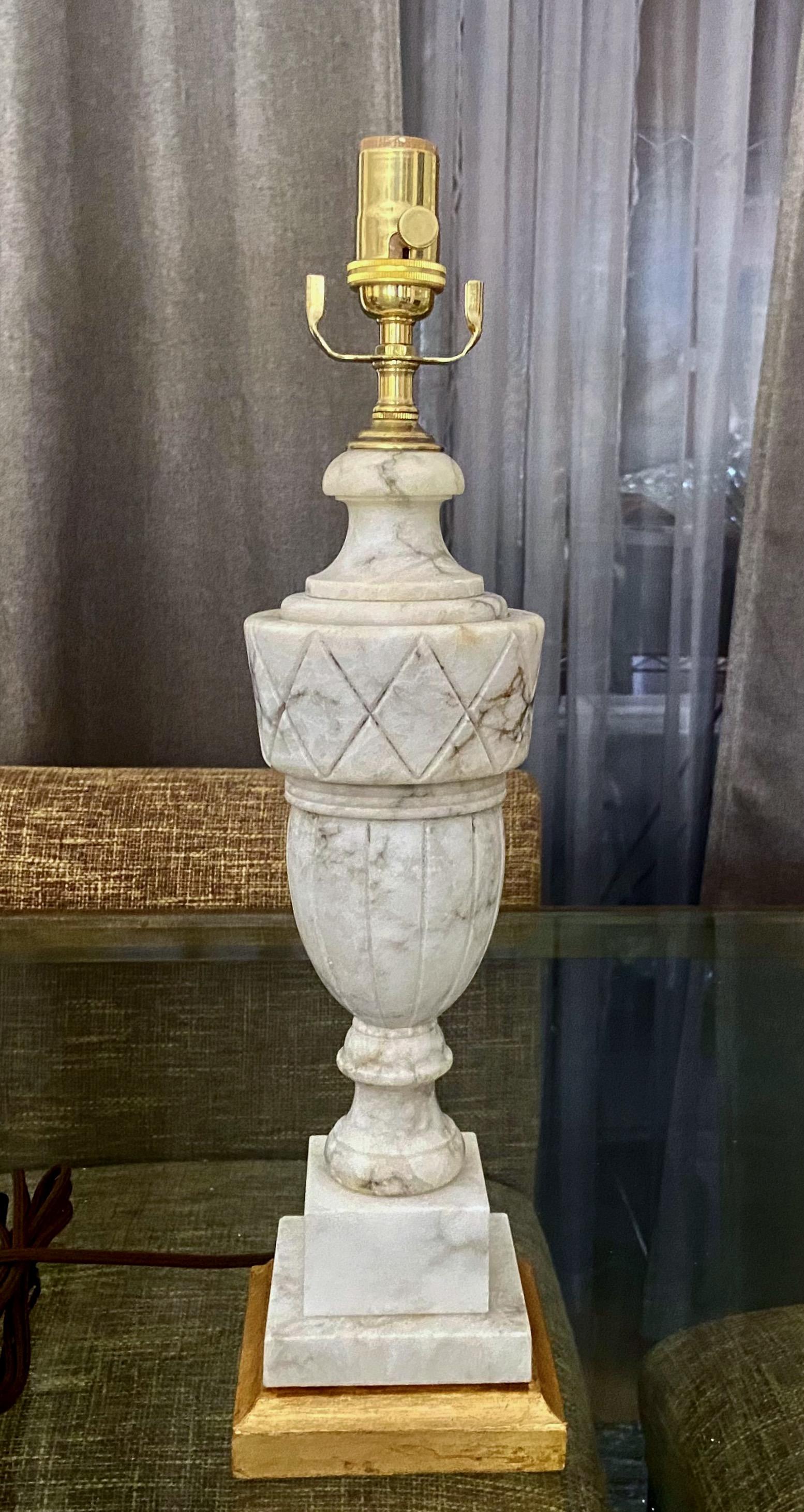 Single finely crafted hand carved neo-classic style urn form alabaster lamp on giltwood base. Newly wired with 3 way socket and rayon covered cord.
Height to top of alabaster is 15.5