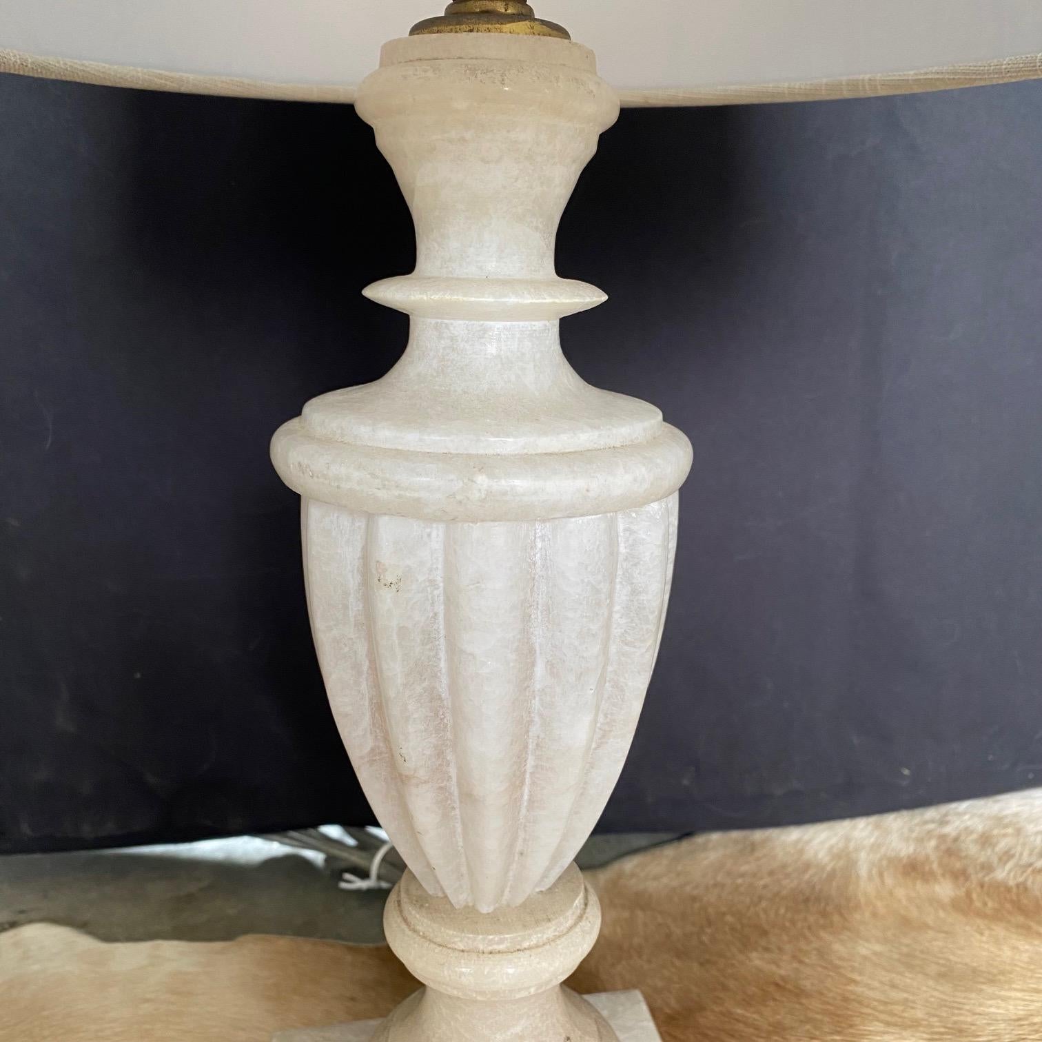 Single finely crafted hand carved neo-classic style urn form alabaster lamp. New shade included. Measures: Diameter shade 12” x Diameter lamp 4.75”
#2571.

