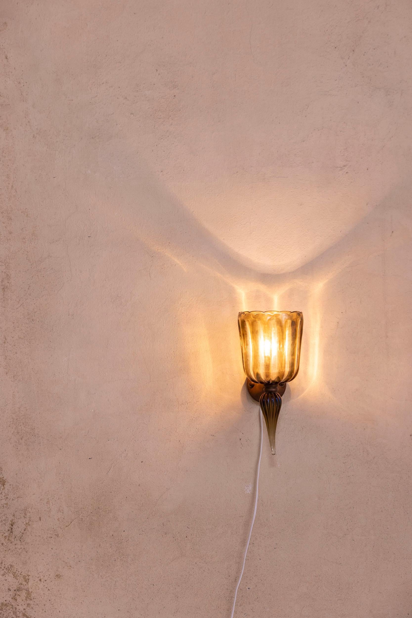 Single Murano sconce by Seguso, Italy, 1950

Elegant single large sconce crafted in Italy in the 1950s by Seguso, featuring exquisite hand-blown Murano glass in warm brown tones. The glass showcases refined and intricate craftsmanship, typical of