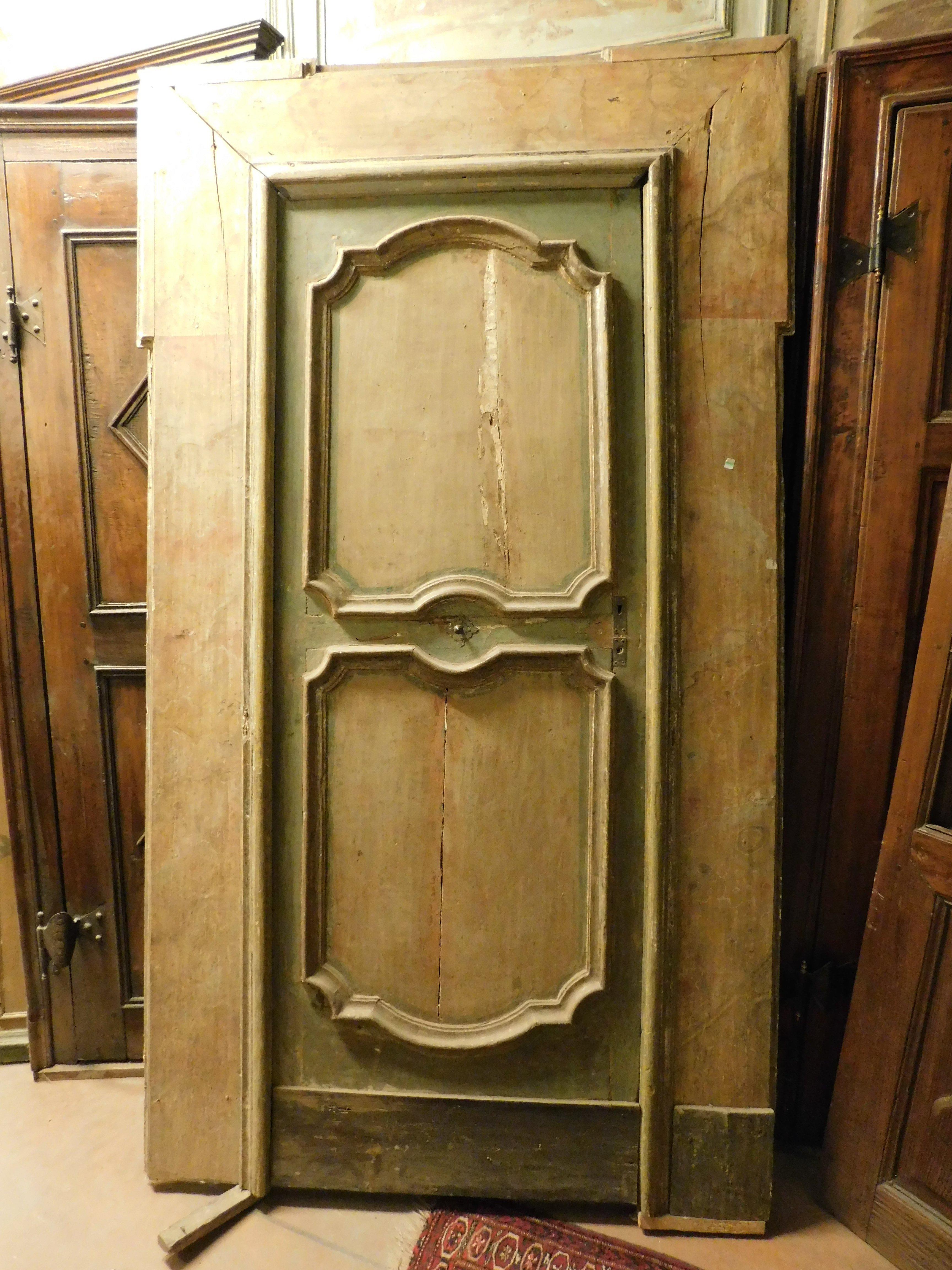 Porta interna antica, composta da un battente in legno laccato e completa di cornice laccata con effetto finto marmo, colori patinati terra e verde, ha un'apertura a spinta a sinistra e un'importante cornice con orecchie. Originale del XVII secolo,