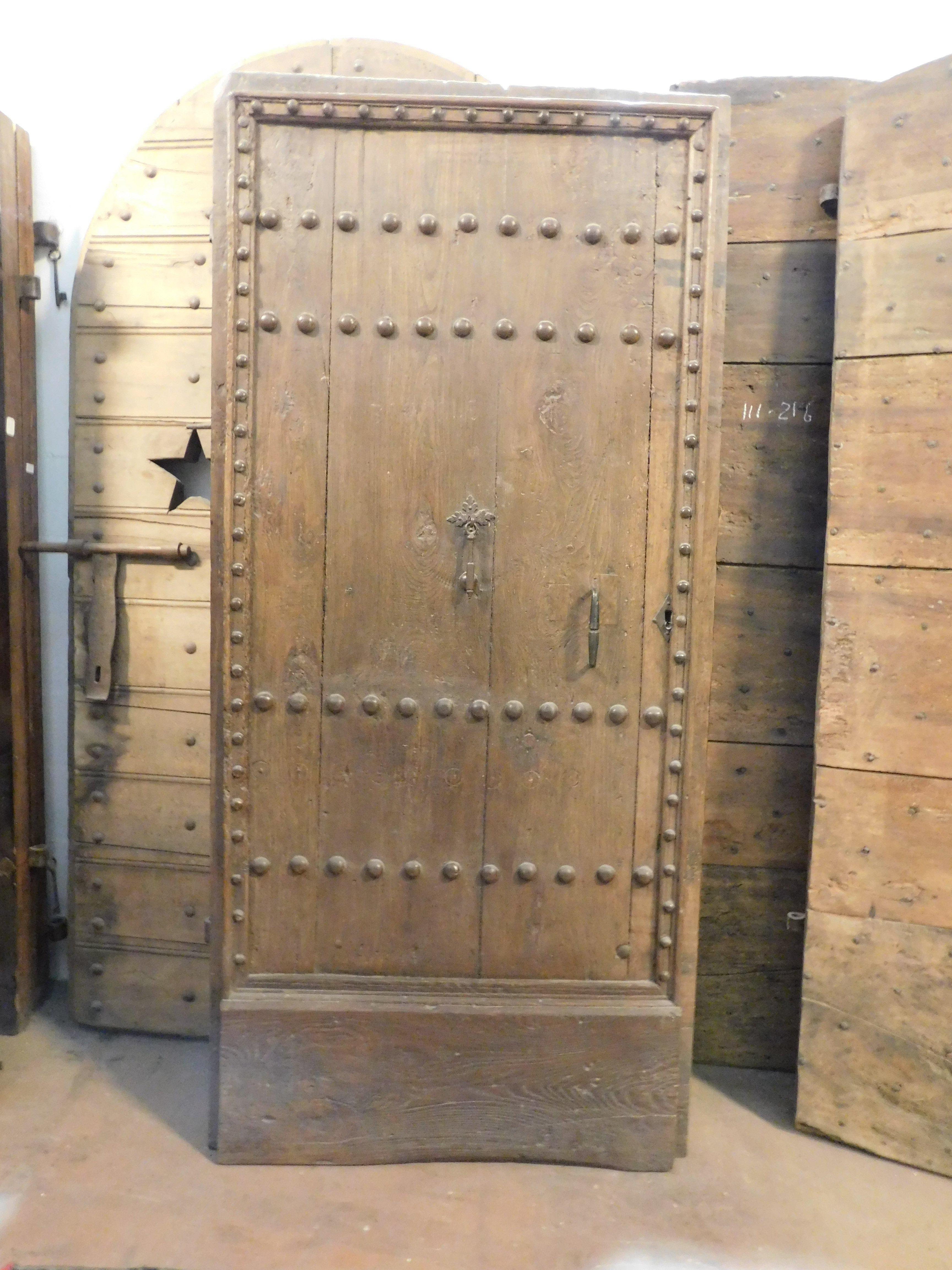 Antique entrance door, main door nailed to a single leaf, in solid chestnut wood, complete with original knocker and handle, partly nailed and smooth back with horizontal bands.
Push opening, to the left. Original from the 18th century, of Italian