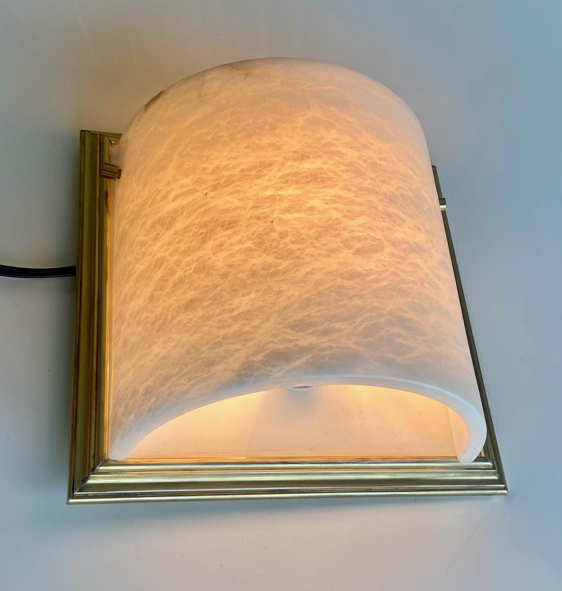 Single Lightolier curved alabaster wall light sconce with brass fittings and brass plated trim backplates. Uses single 60 watt regular A size bulb.
