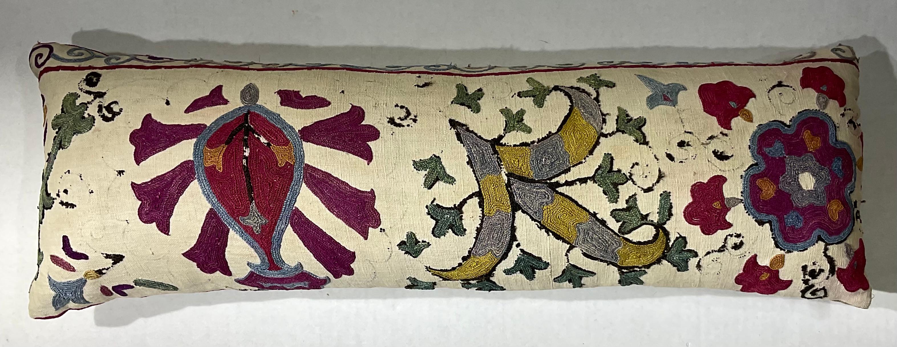Coussin simple en tissu Suzani ancien, brodé à la main sur soie, avec de magnifiques motifs de vignes et de fleurs. Insert de qualité fraîche, support en coton fin. Quelques broderies manquantes dues à l'âge et à l'oxydation, quelques taches de