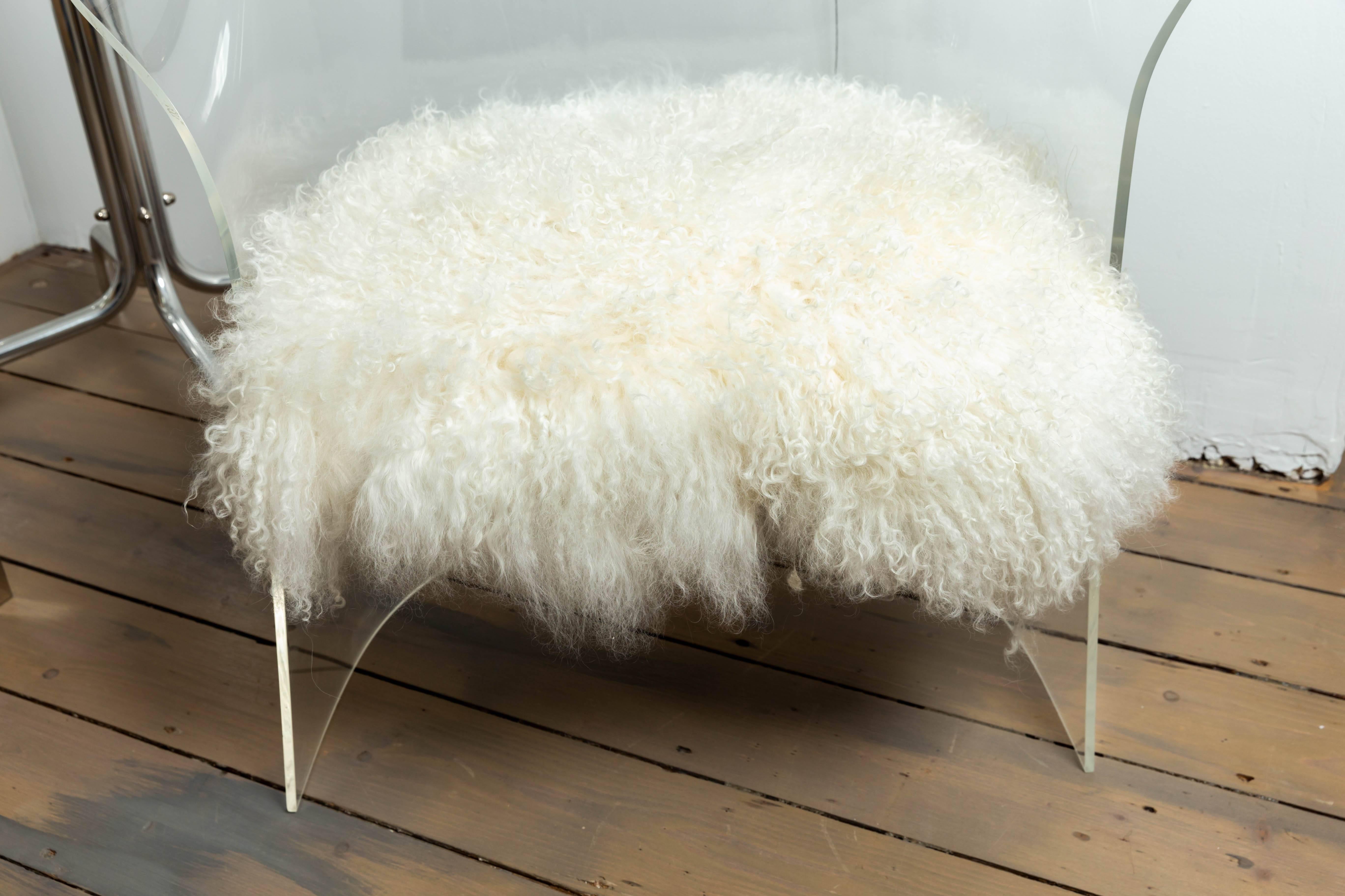 Single Lucite barrel-back chair with shearling upholstery and brass detail.