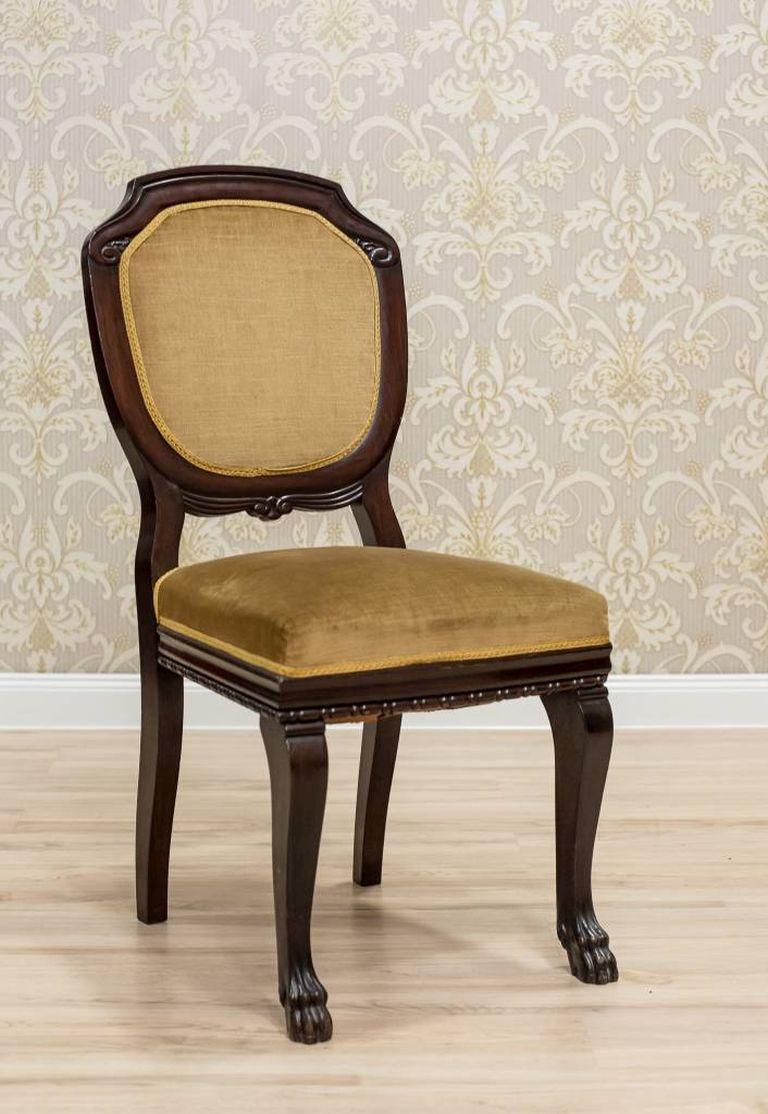 A chair made in mahogany wood with an upholstered, spring seat, and a backrest in the form of a medallion.
The frame of the chair in a hot bronze color is ornamented with spare decorations, which has been limited to a delicate woodcarving around