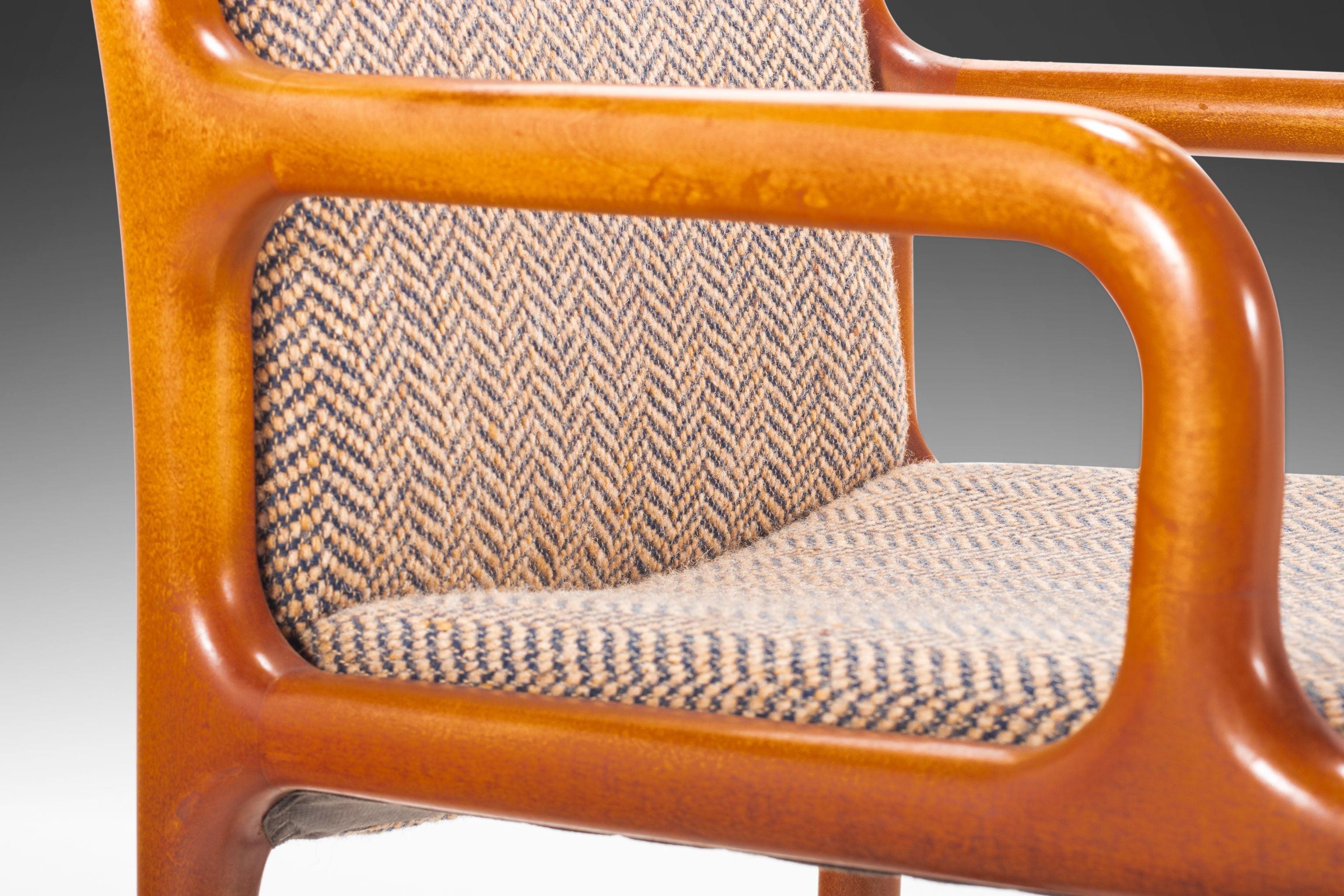 Esta juguetona silla con forma de pretzel no se parece a ninguna otra que hayamos visto. Construido con madera de roble maciza, tejido de tweed original con encantadores motivos geométricos y con una intrincada carpintería sin costuras, este sillón