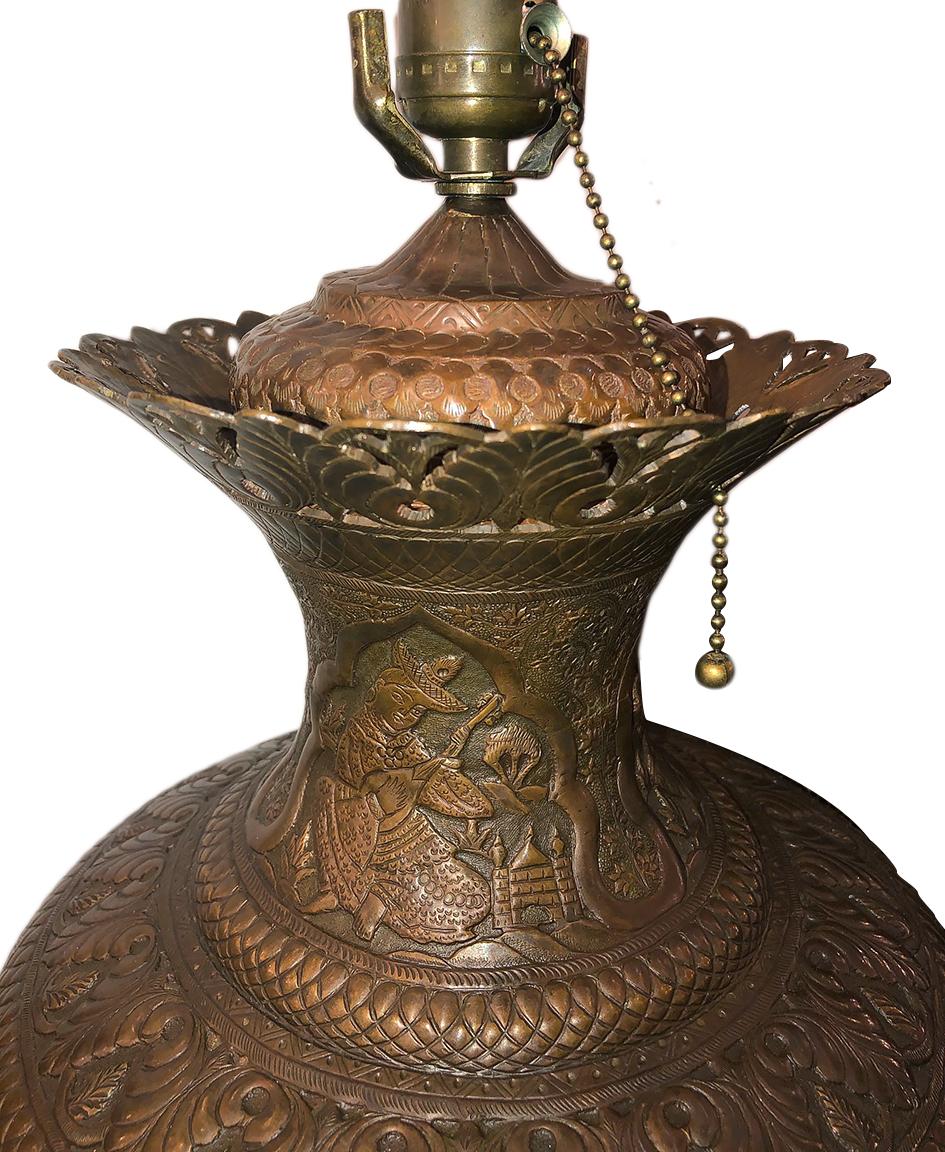 A circa 1950s Middle Eastern pierced copper table lamp with hand-tooled design.

Measurements:
Height of body 19