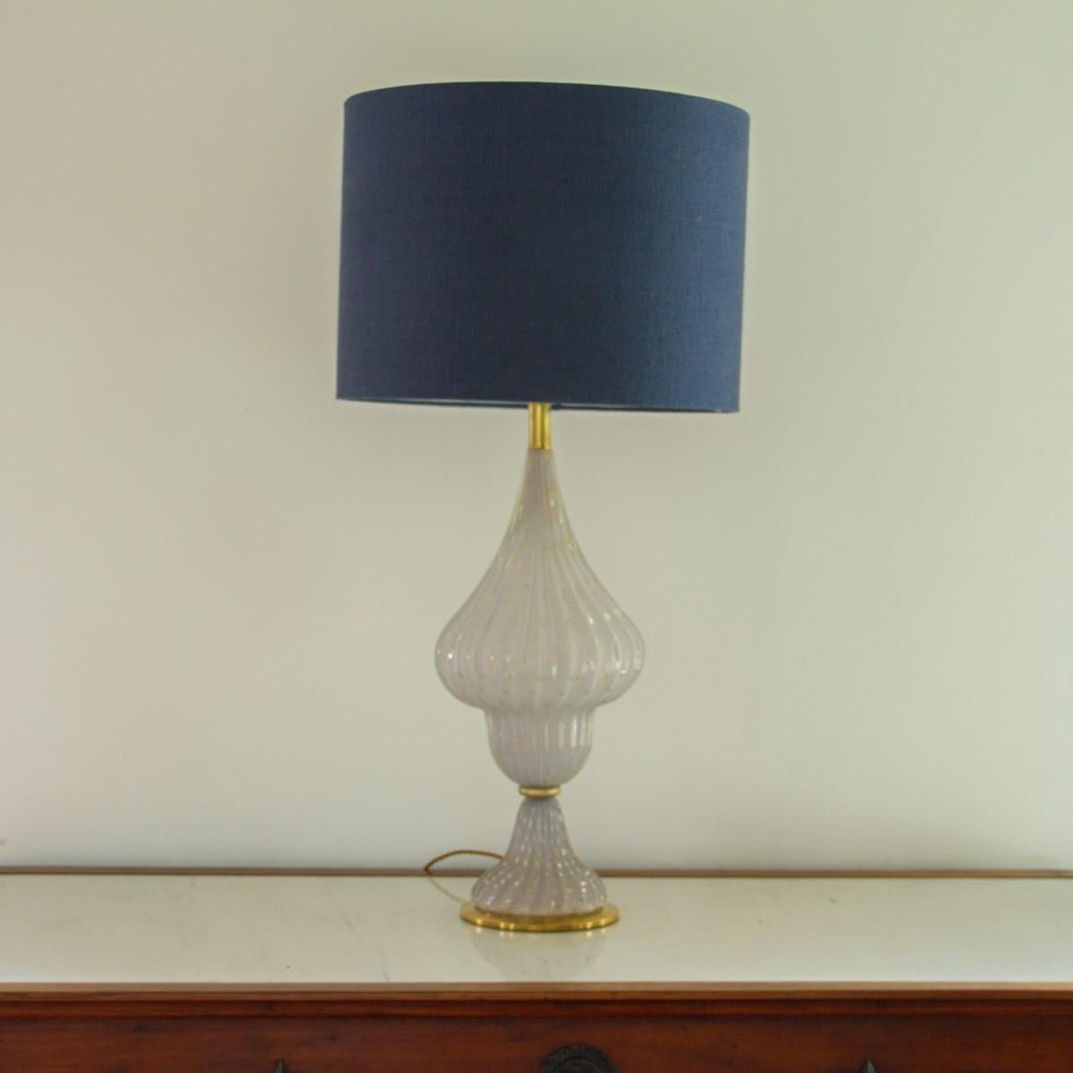 A single psykter shaped lamp made from Murano white glass which has been ribbed and blown with gold bubble details throughout. The lamp is set on a brass base and has brass details accentuating the shape,1960s. We also have a pair of matching