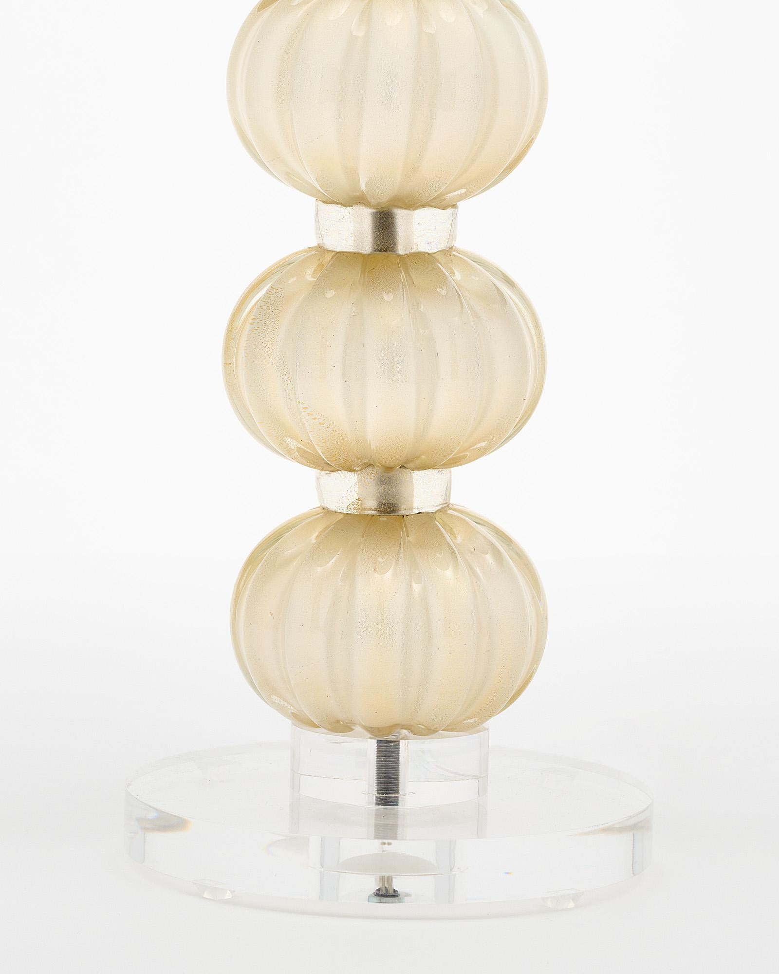 Single lamp from Murano, Italy made of hand-blown glass spheres with ridges and 24 carat gold powder fused into the glass. It sits atop a Lucite base. It has been newly wired to fit US standards.
