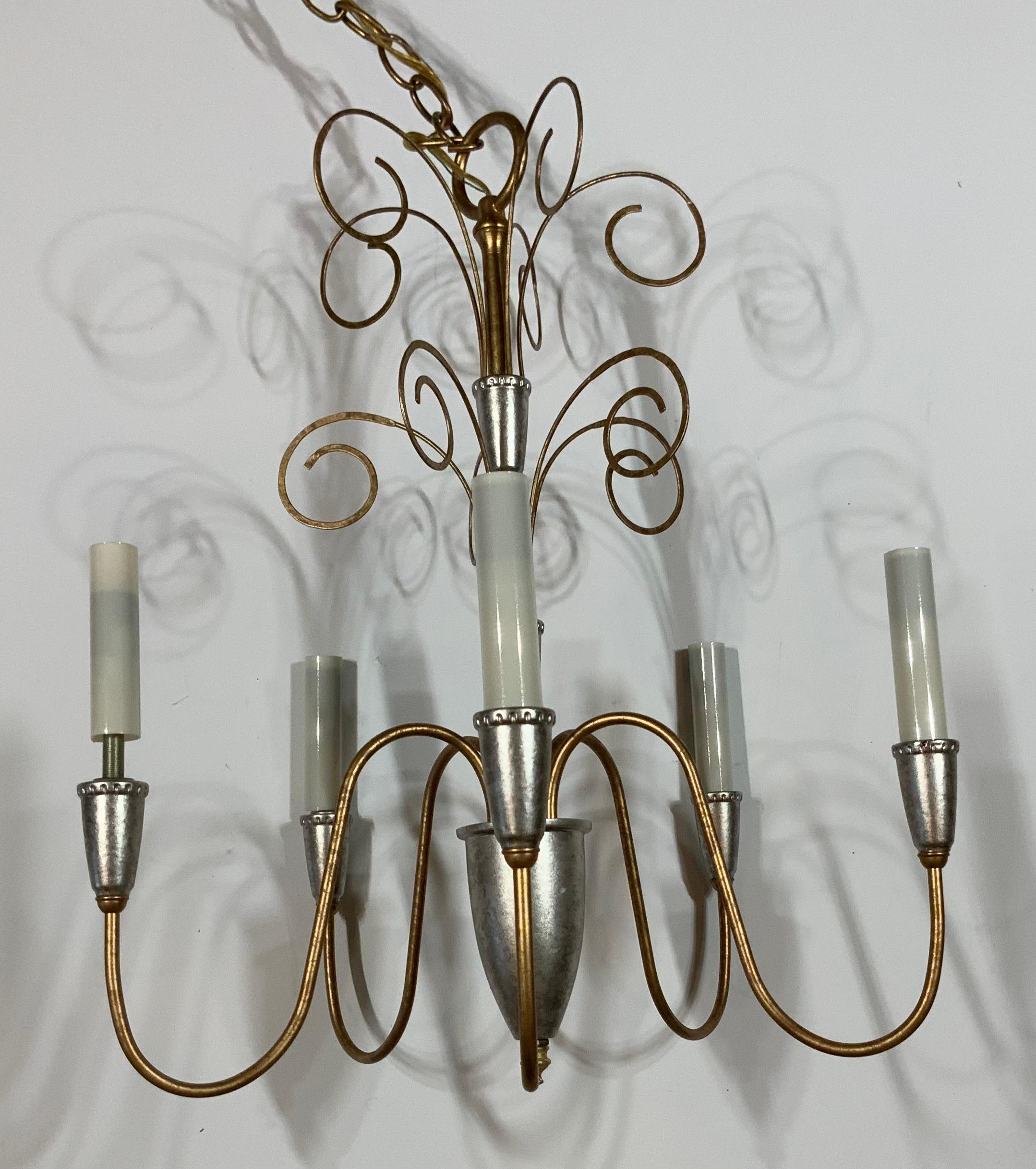 Elegant chandelier made of metal, painted in silver and gold, with five stems 60/watt light each stem 
Electrified and ready to use. Beautiful and clean cut chandelier for any room 
One more is posted
Original canopy and chain included.
    