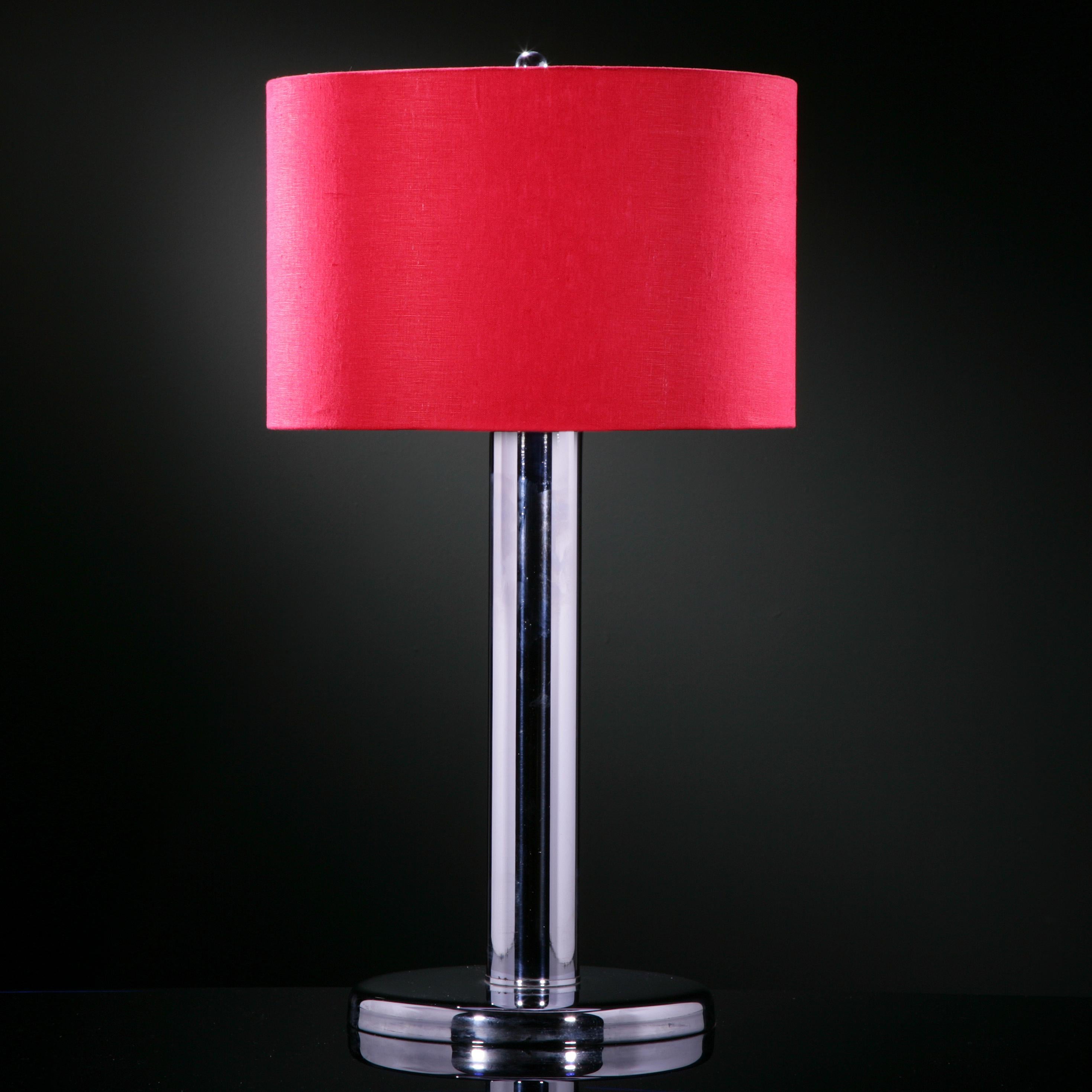 A single nickel-plated tubular table lamp with a red linen shade, 1960s.