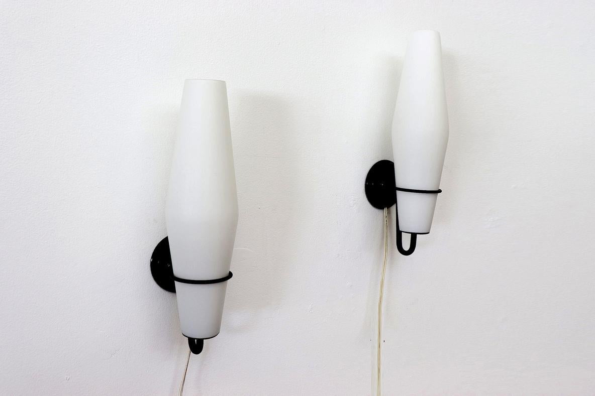 Philips wall sconce with black enameled metal frame and milk glass light shade. A unique mix of simplistic design with elegant lines and style. In original condition with minor wear consistent with age and use. Others available listed separately.