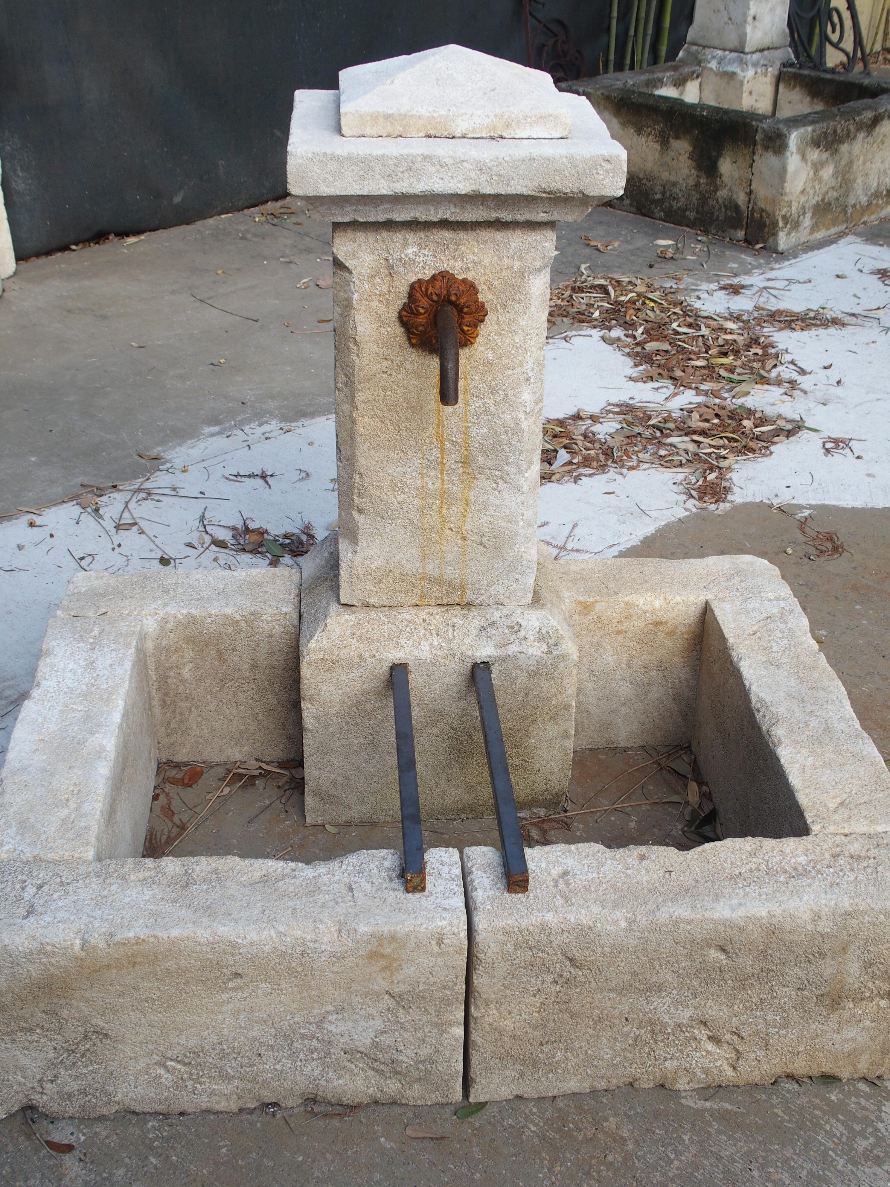 This hand carved and distressed limestone fountain from Provence can be used as a wall fountain or placed in front of shrubbery, gates or other edifices. The top of the fountain is stepped out with a shaped piece on top. A single squared pillar is