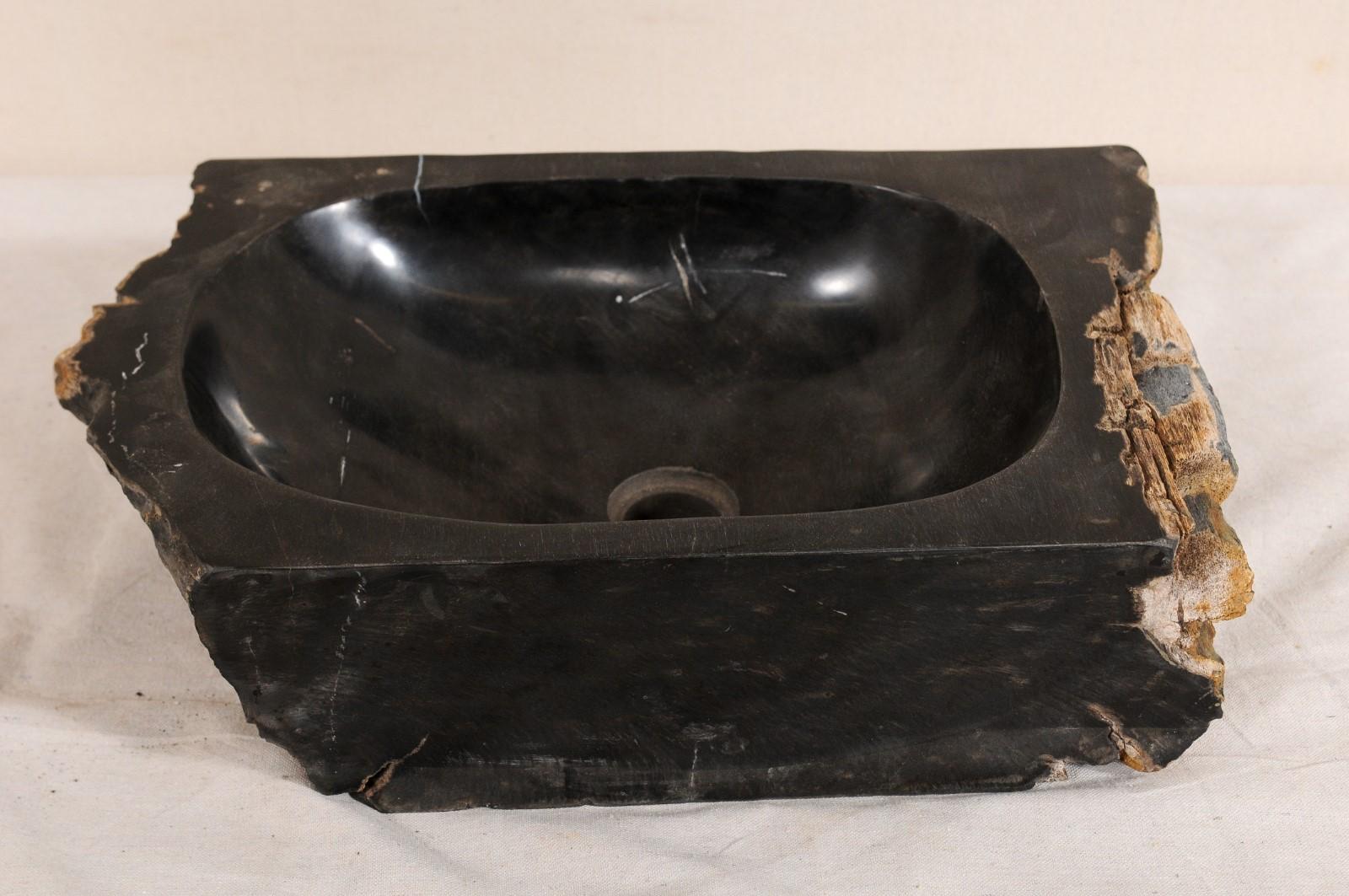 A single petrified wood wash basin. This petrified wood sink has a polished finish basin, making for easy clean-up, surrounded by an unpolished, natural textured exterior. Petrified wood is a fossil, and over time, the wood becomes so sturdy and