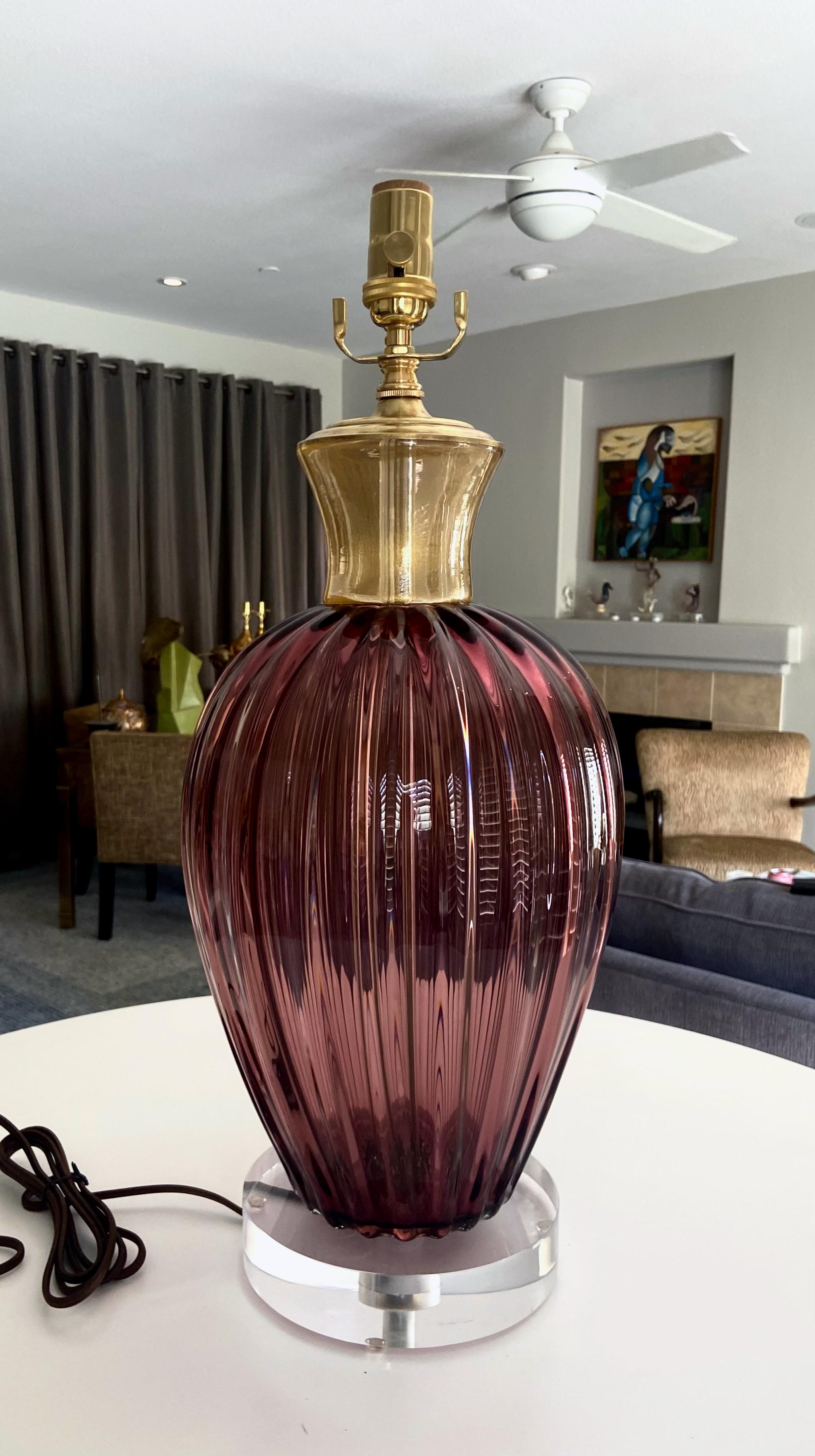 A single wide body Murano hand blown purple and gold infused glass table lamp. The glass purple body is ribbed topped with a clear and gold inclusion neck. The lamp is mounted on newer acrylic base. Newly wired for US with new brass fittings, 3 way
