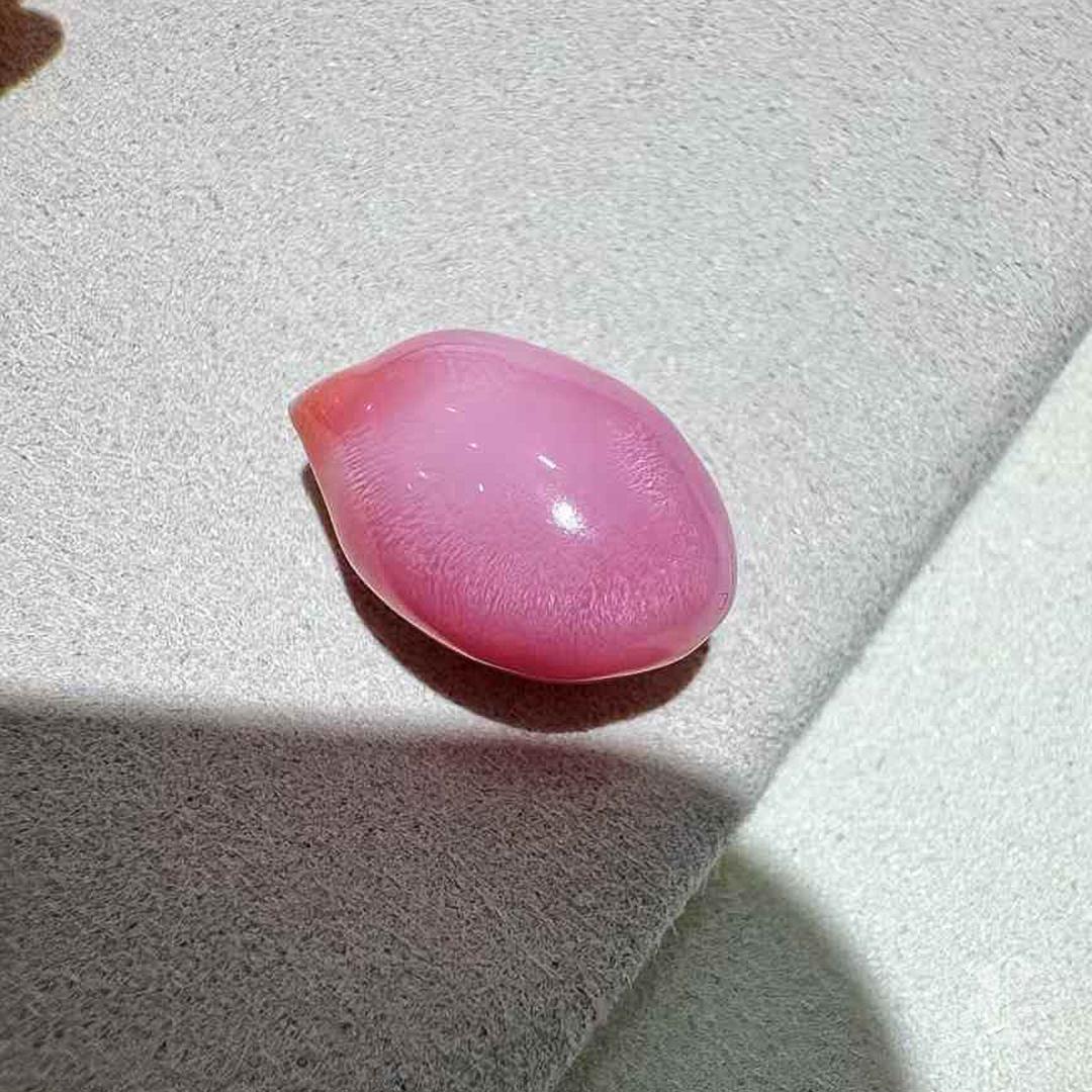 Esta exquisita perla de concha de 8,42 quilates irradia un brillo asombroso y translúcido, extraordinariamente limpio y vibrante. Su rica tonalidad rosa flamingo se acentúa con prominentes dibujos de llamas, creando un extraordinario atractivo