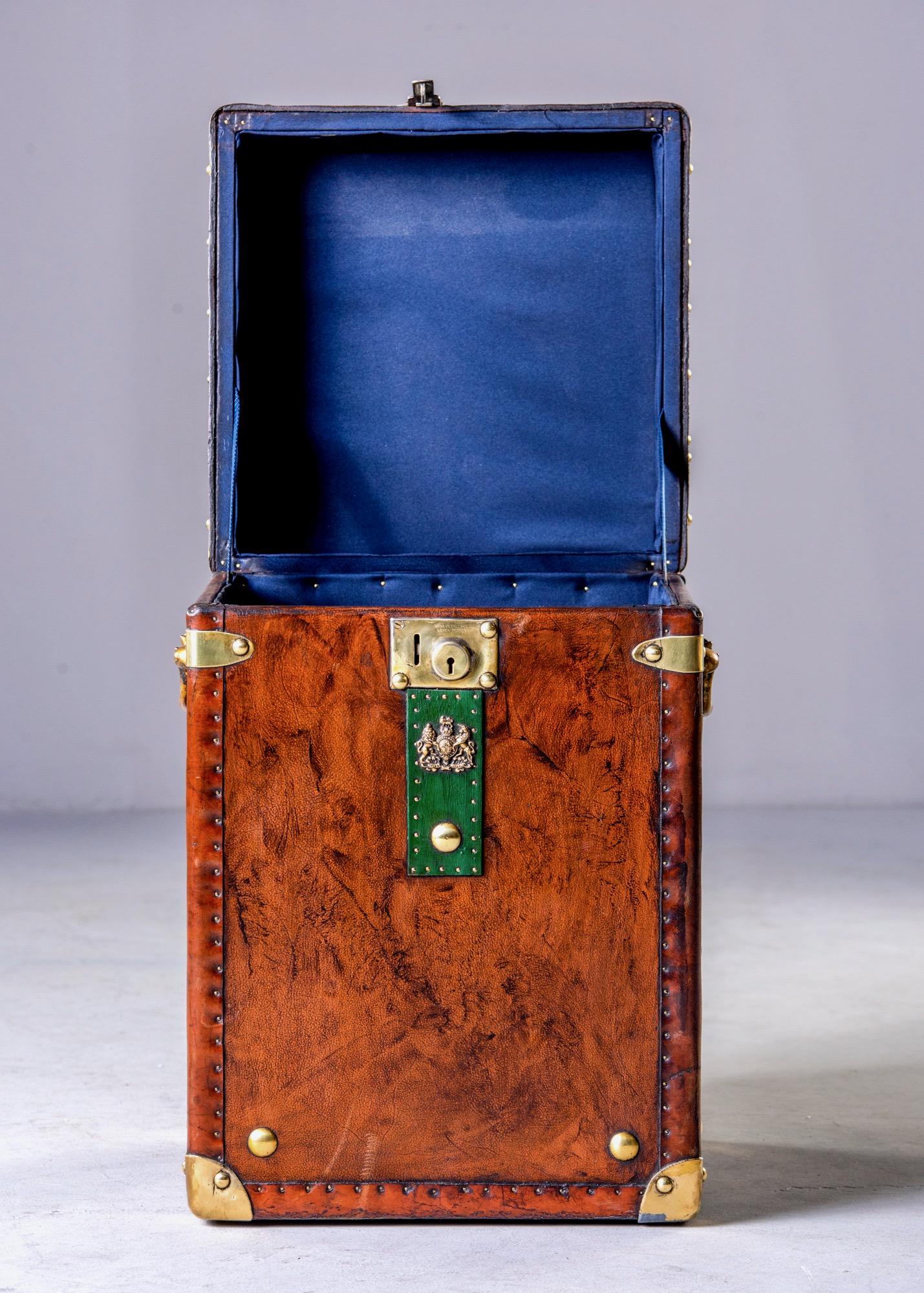 English trunk with restored leather cover, brass hardware, green strap and new blue velour lining, circa 1900s. Makes a great unique side table. Unknown maker.
