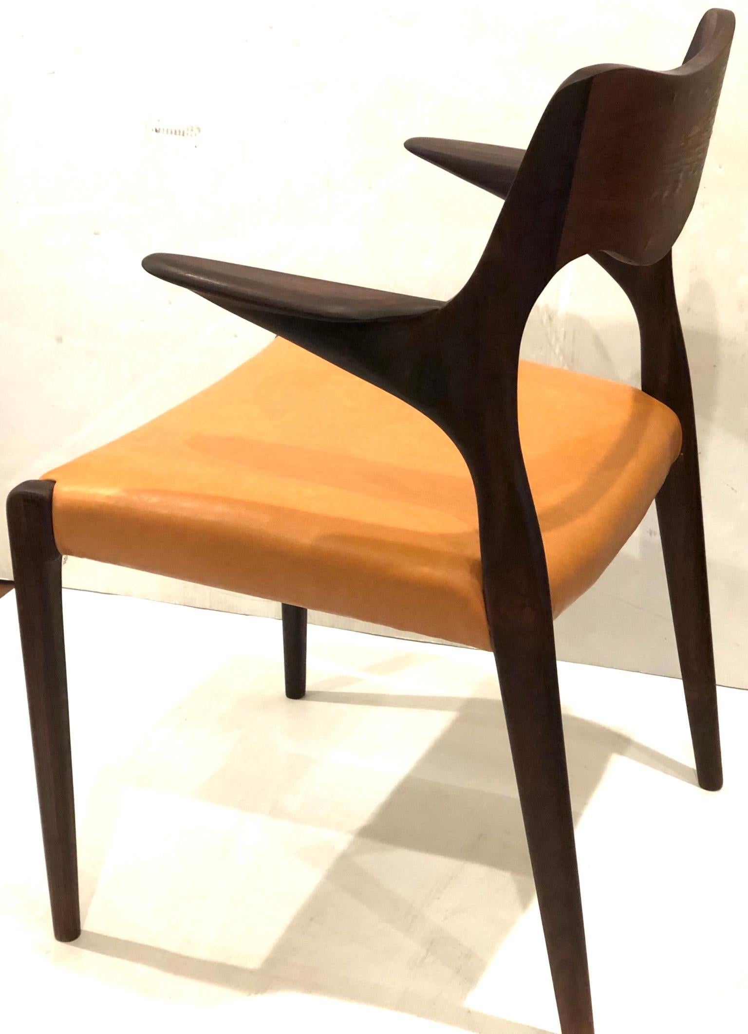 Beautiful single sculpted armchair, in rosewood frame and caramel color Naugahyde seat great design beautiful lines, solid and sturdy designed by Niels Moller, circa 1955. The chair its in good condition solid and sturdy with some bubbles or