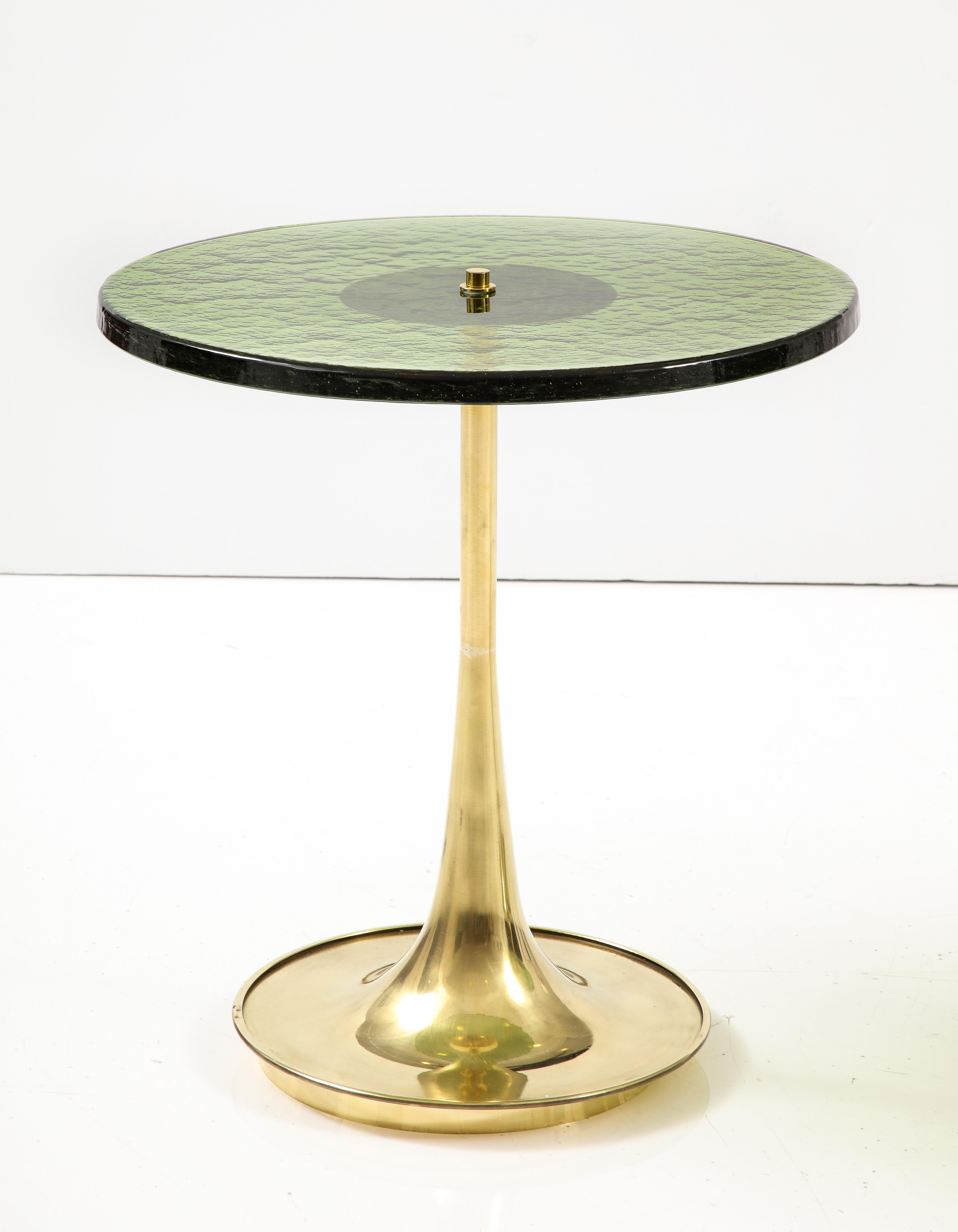 Round green Hue Murano glass and brass martini or side tables, Italy, 2023. Hand-casted 1 inch thick, solid, deep green colored Murano round glass top sits atop a hand-turned, trumpet-shaped brass base. A modern flat top brass finial screws the