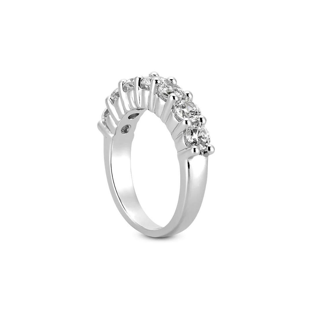 Single row classic prong set diamond band in 14k white gold. Band contains seven natural, round white brilliant cut diamonds, weighing a combined carat weight of 0.55 ctw, G-H color, SI clarity. Comfort fit