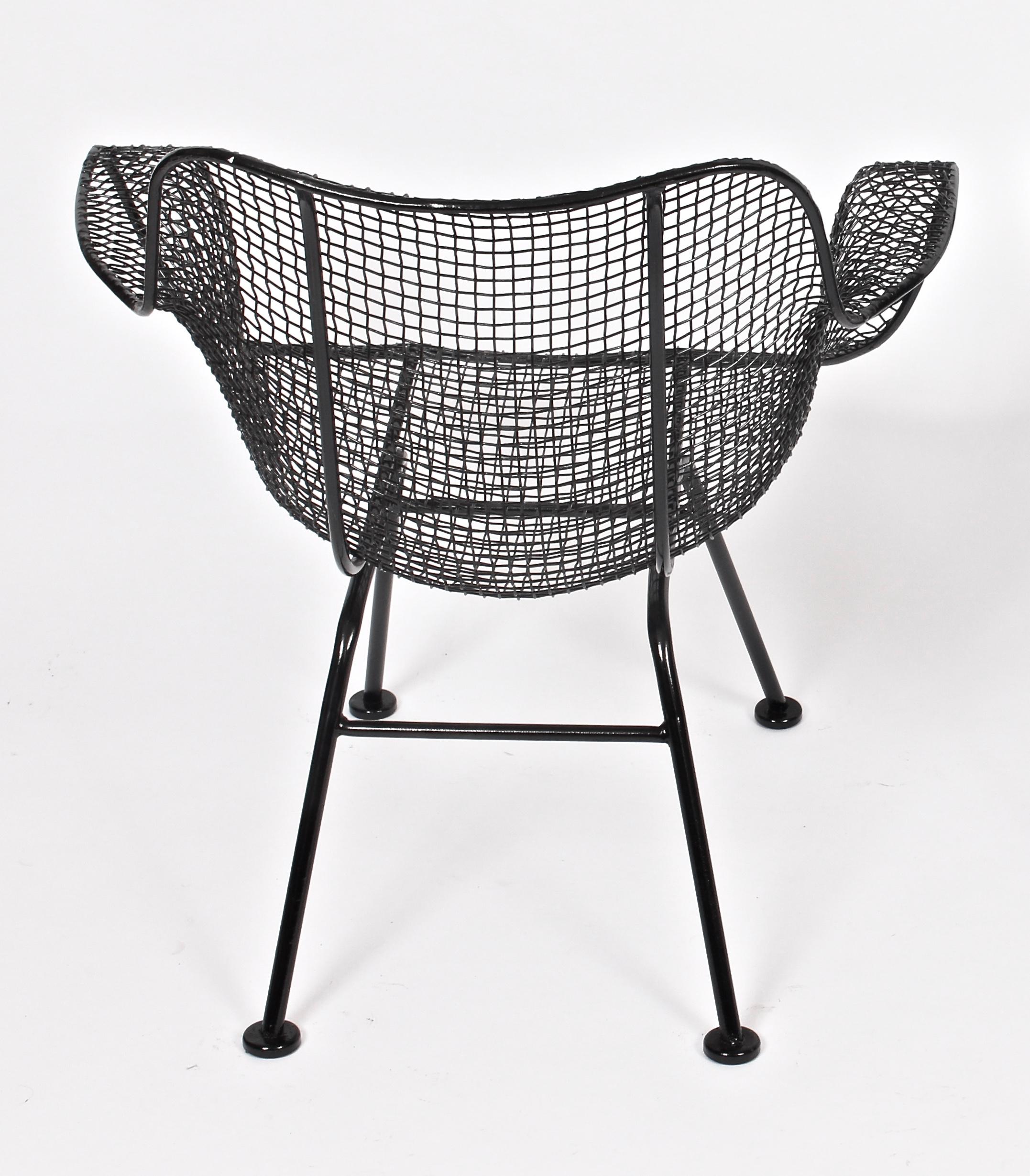 Original Russell Woodard black wrought iron and wire mesh linai armchair 1950s. Featuring a glossy black enameled Iron framework with sculpted black wire mesh. Classic. Comfort. Indoor outdoor. Lightly restored. Freshly powder-coated. Like new. Up