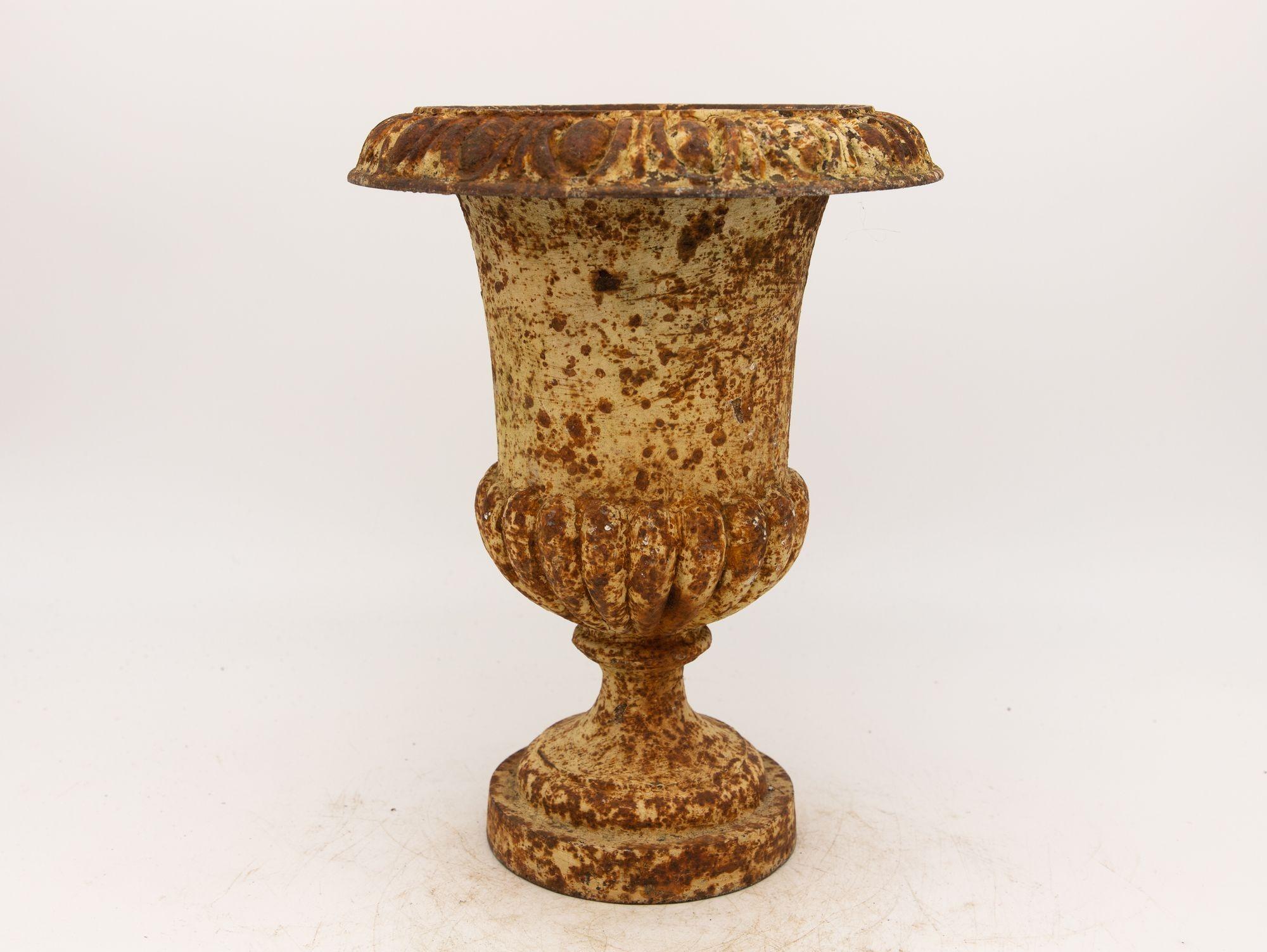 This cast iron urn is a beautiful example of French early 20th-century design. It has a timeless quality that makes it a perfect addition to any garden or outdoor space. The urn is made of solid cast iron, which gives it substantial weight and