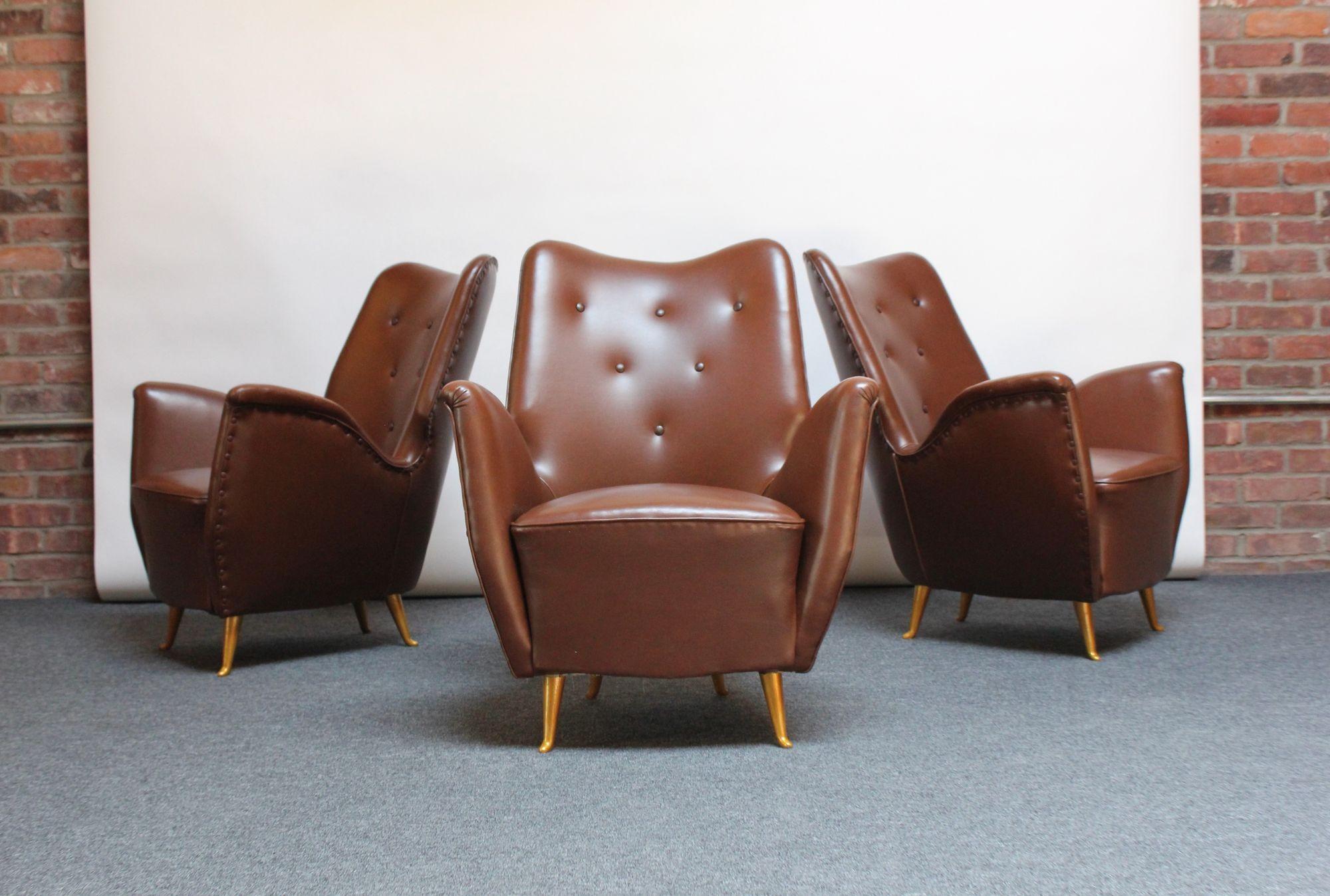 Low and petite Isa Bergamo armchair attributed to Gio Ponti characterized by pronounced/exaggeratedly sculpted arms in chocolate vinyl with button tufted details (ca. 1950s, Italy).
Original spring construction present with the frame supported by